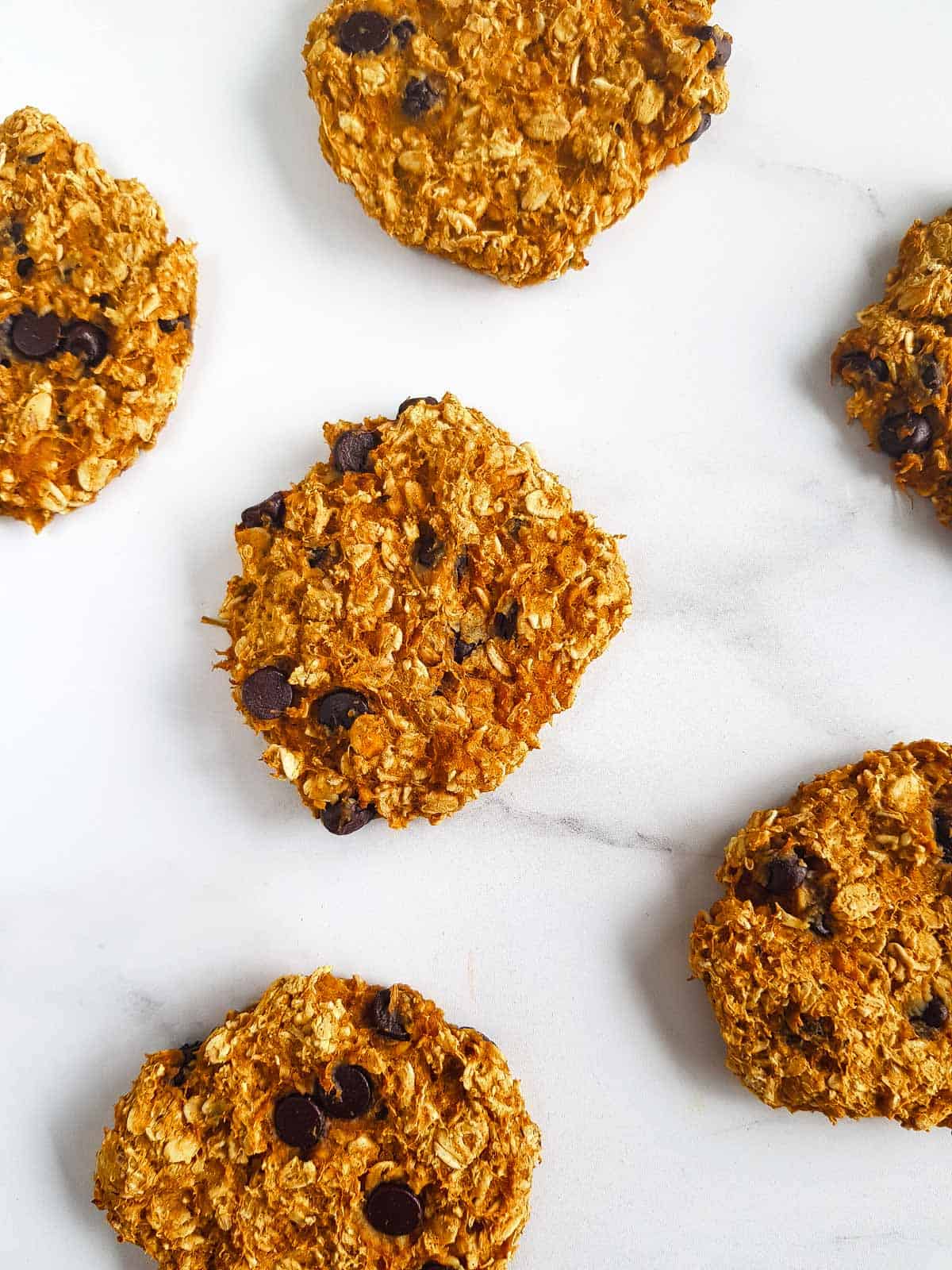 Pumpkin oatmeal cookies laid out on a table.