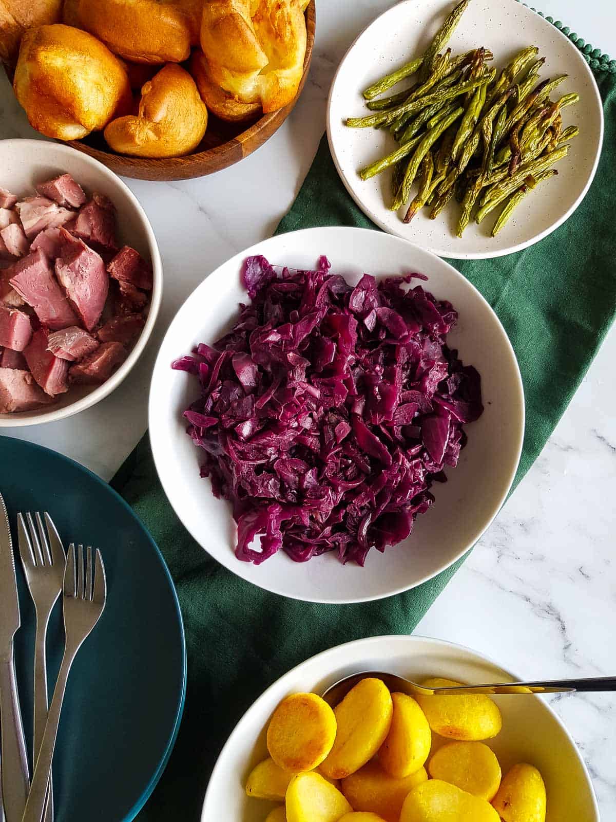 A roast dinner table with several side dishes, including red cabbage.