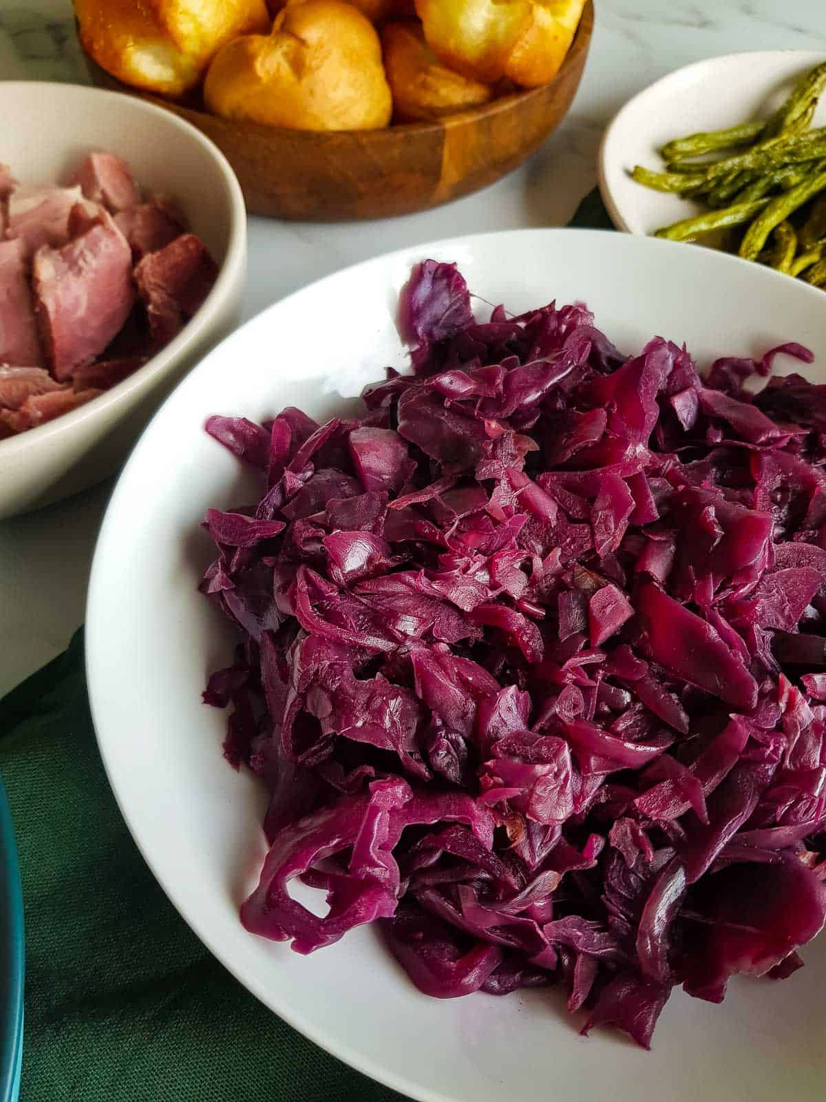 Close up of red cabbage in a bowl at a dinner table.