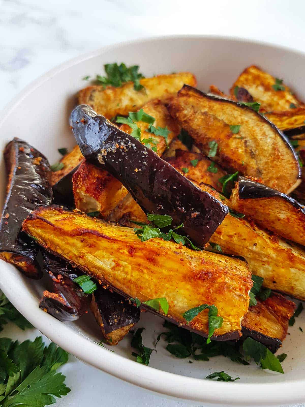 A close up of air fried eggplant fries.