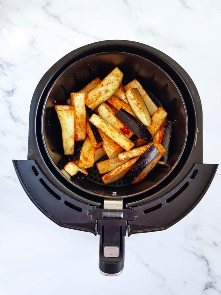 Uncooked eggplant in an air fryer.