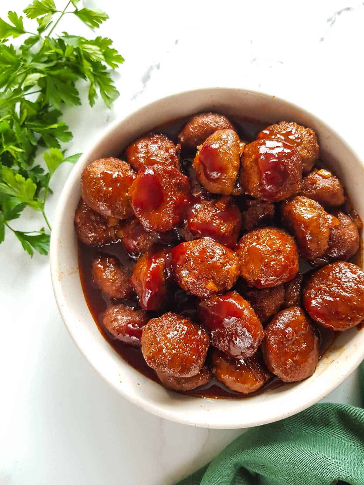 BBQ meatballs with parsley on the side.