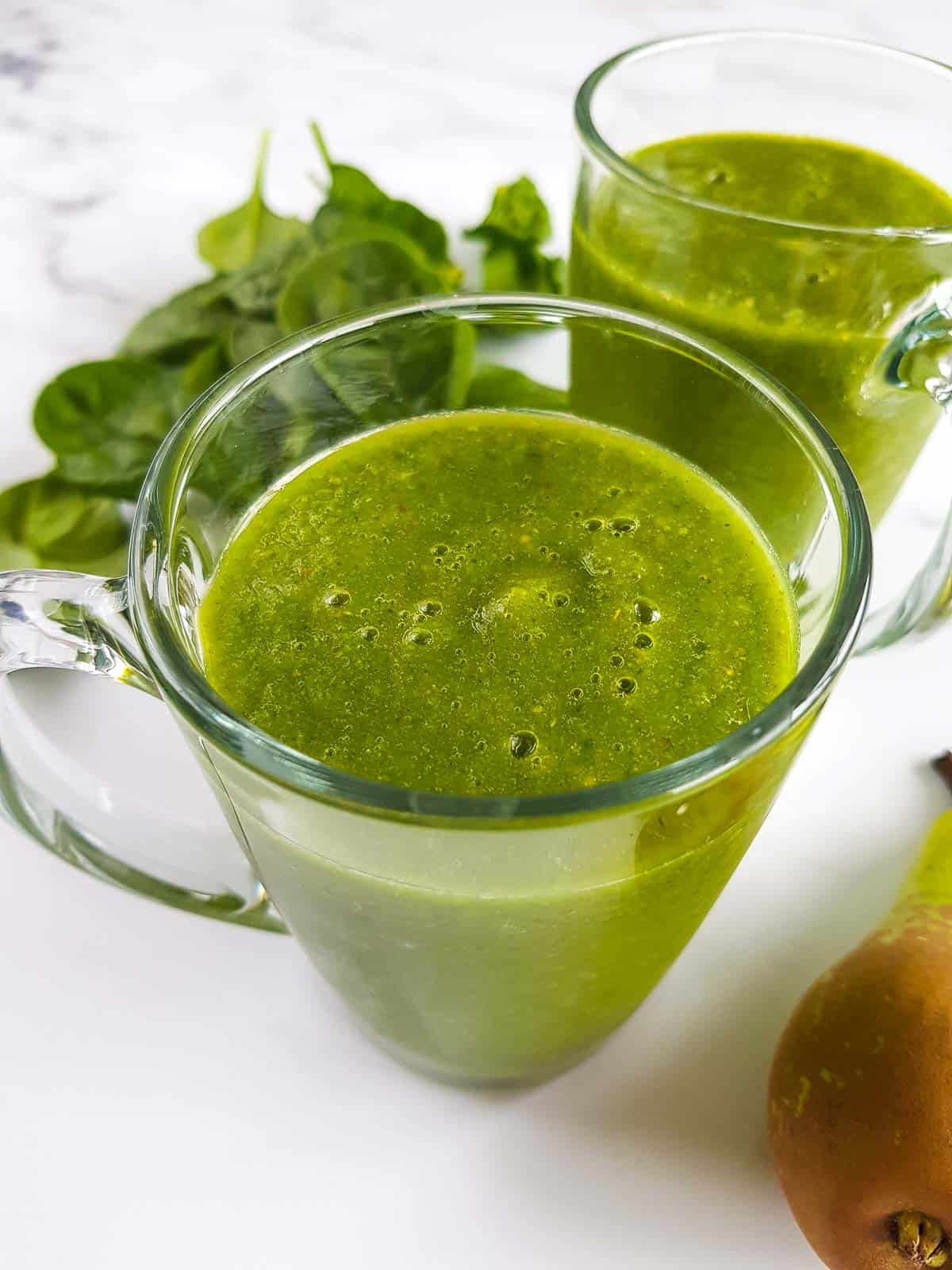 Two cups of spinach and pear smoothie.