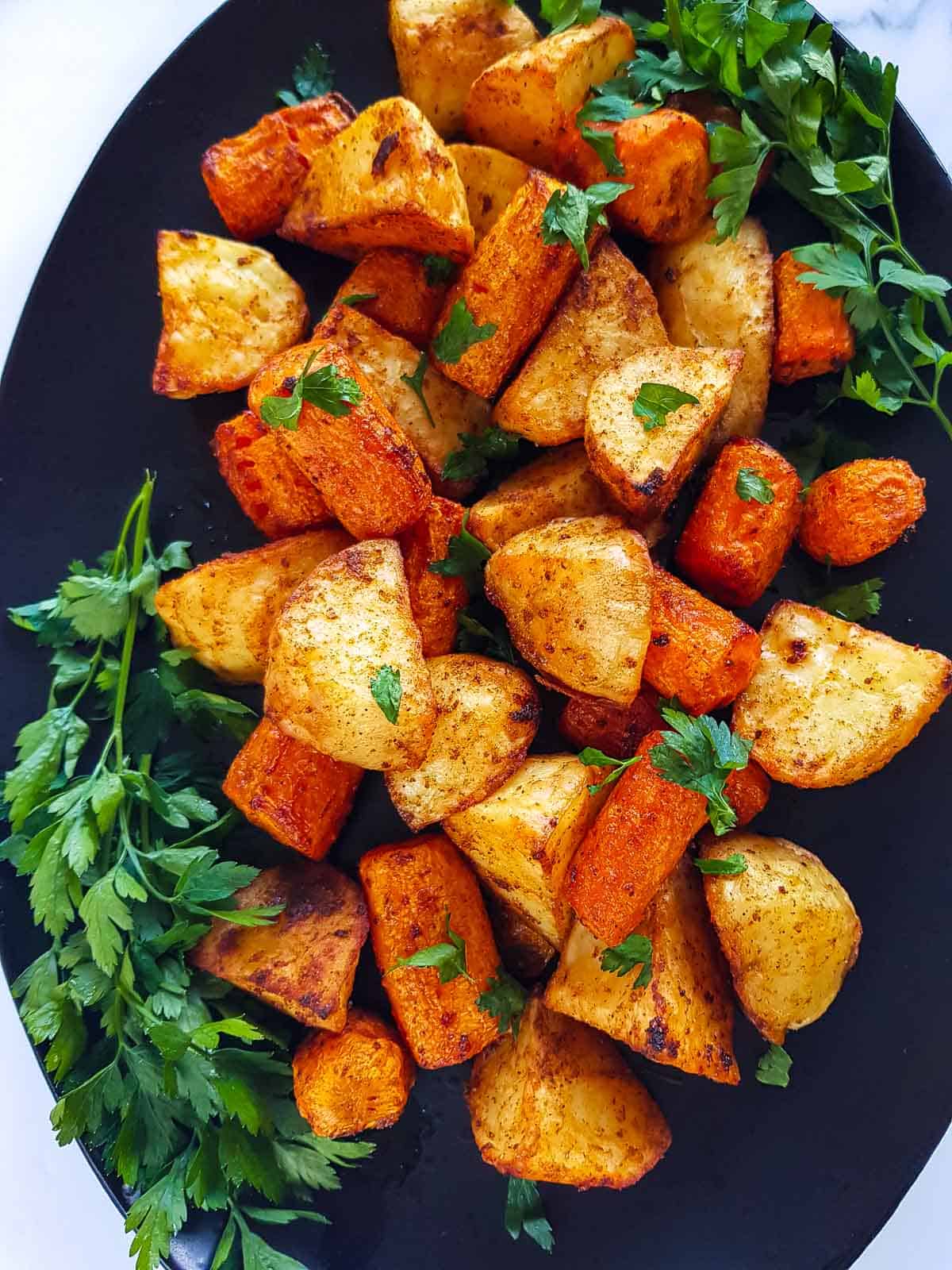 Roasted potatoes and carrots on a serving platter.