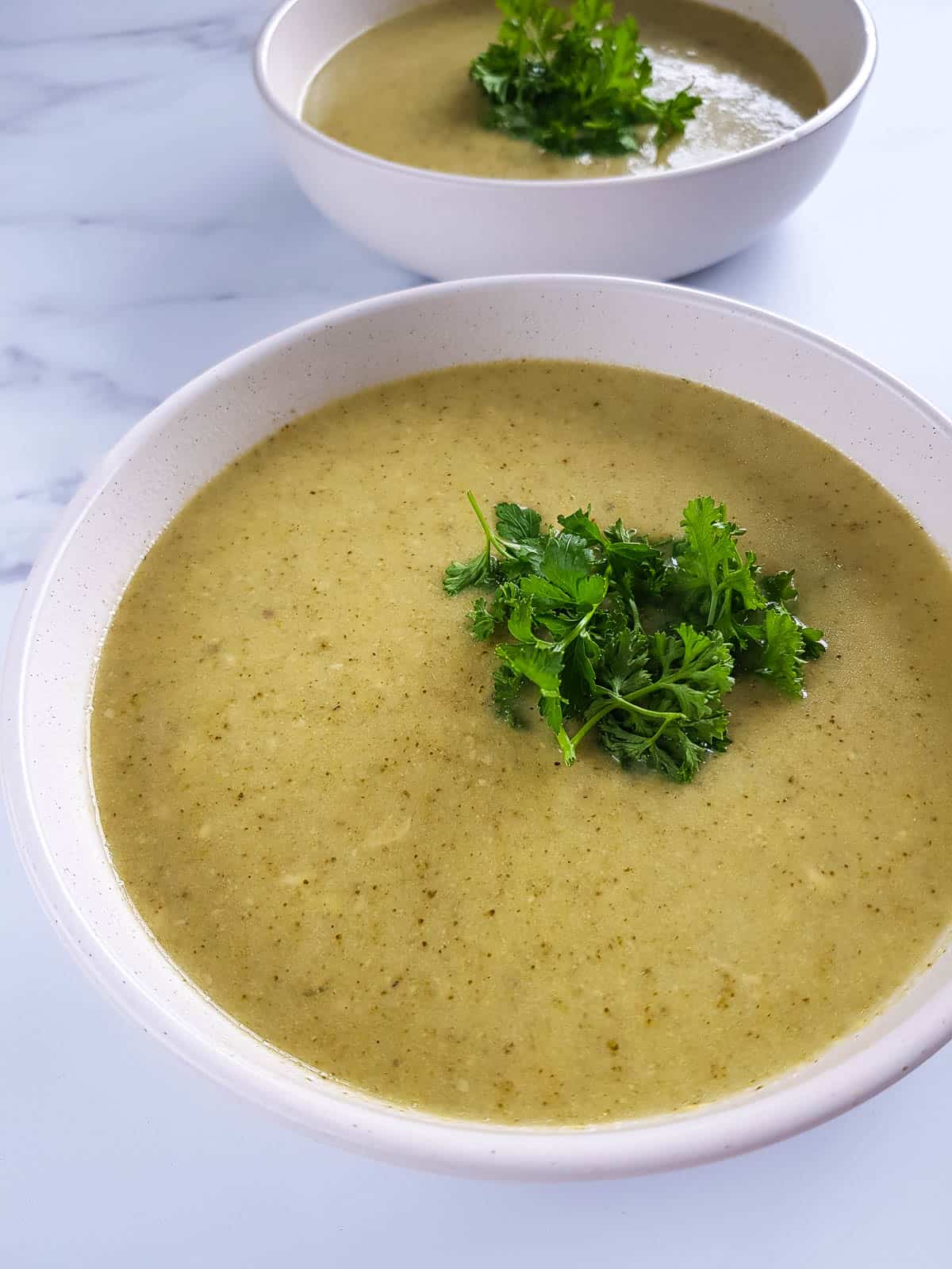 Close up of a bowl of broccoli cheese soup.