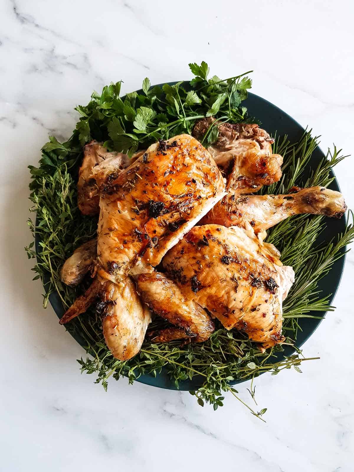 Carved butterfly chicken on a plate.