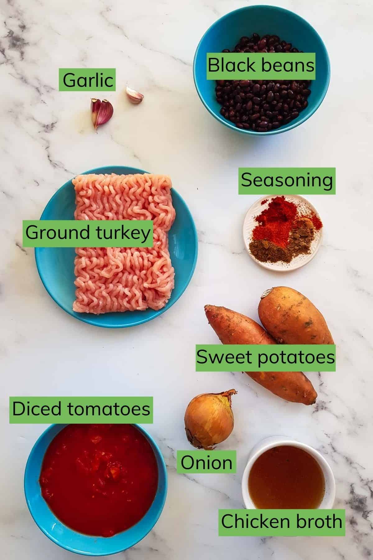 The ingredients for turkey sweet potato chili laid out on a table.