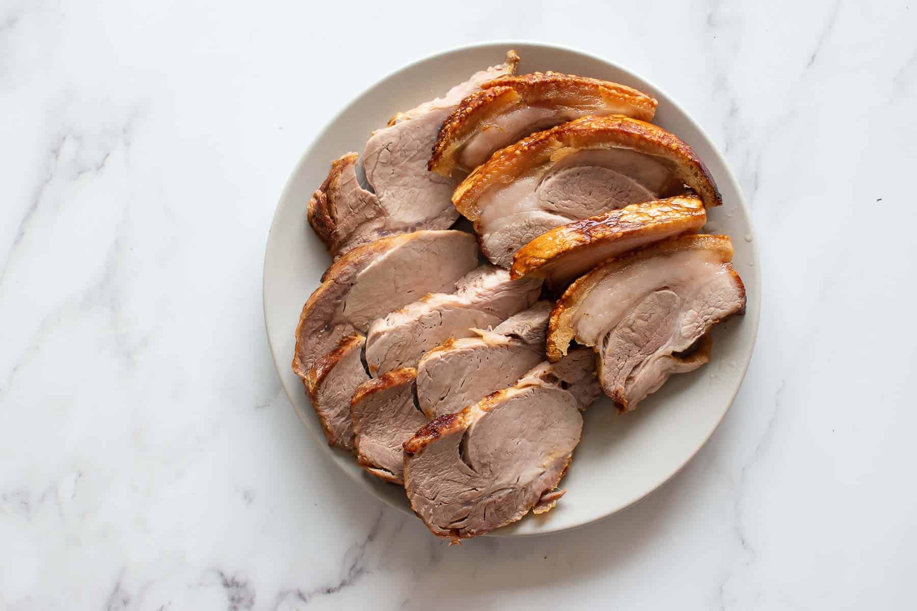 A plate with sliced air fried pork roast.