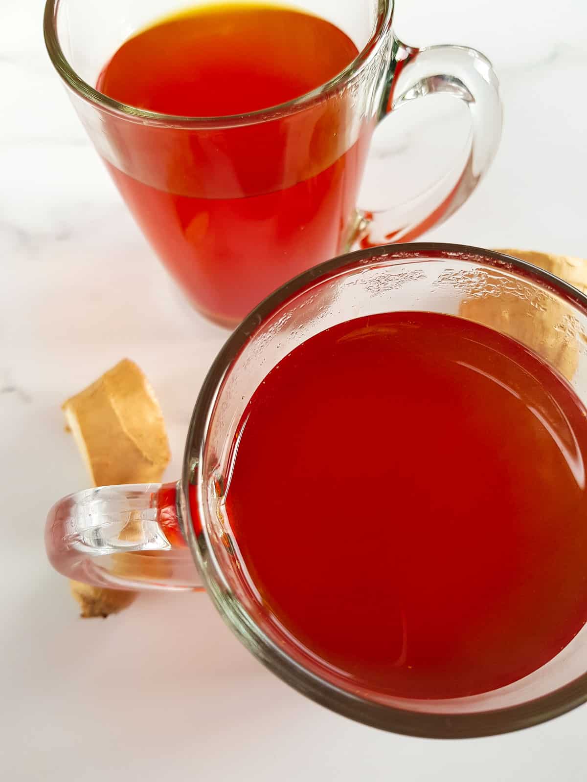 Close up of a glass of turmeric and ginger tea.