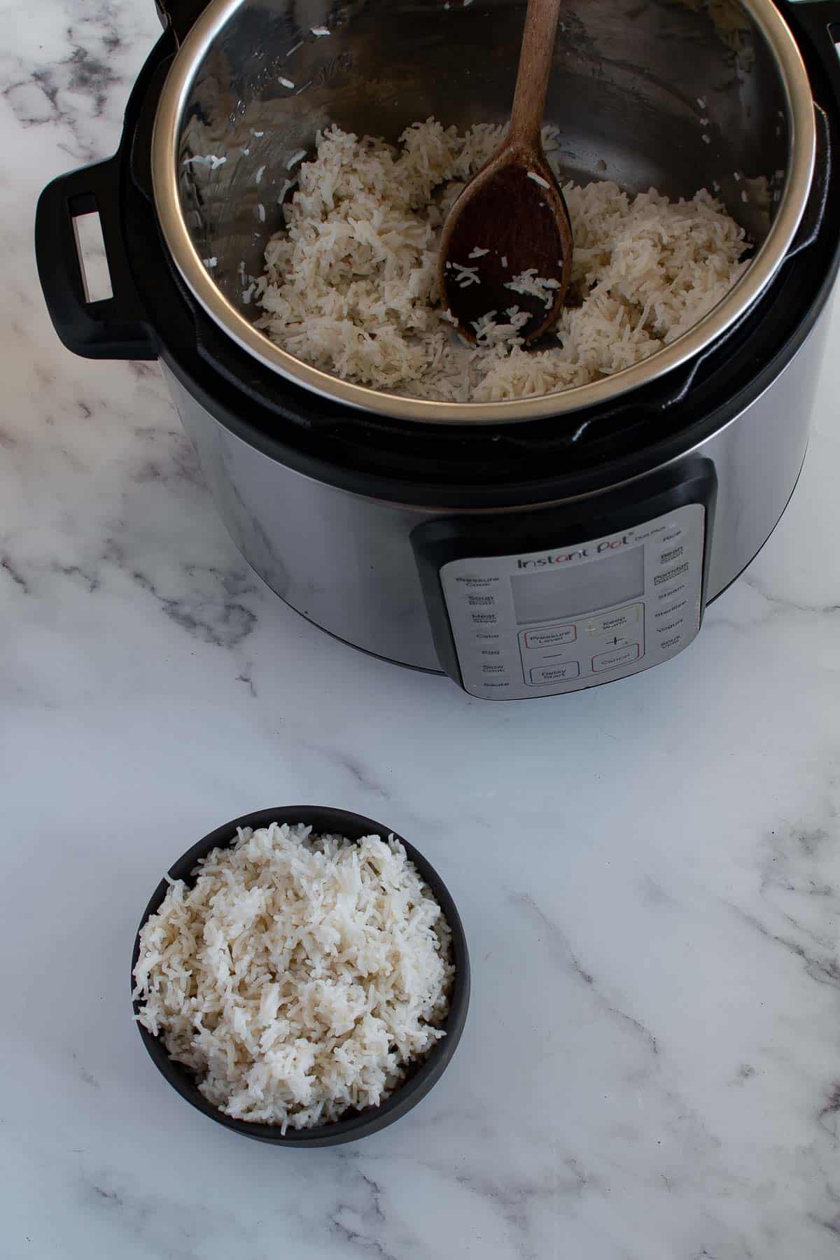 Overhead picture of a bowl of rice and an instant pot filled with rice on a table.