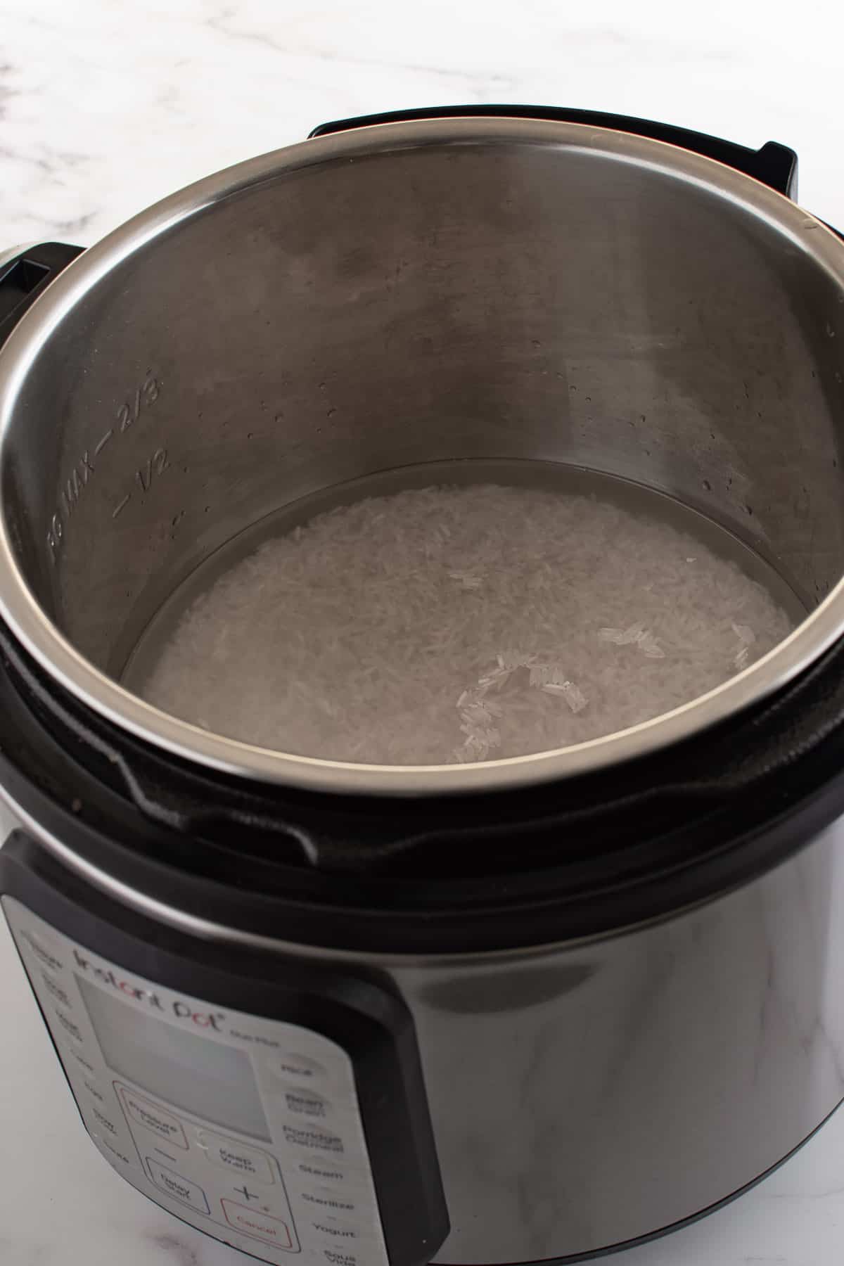 An instant pot filled with rice and water.