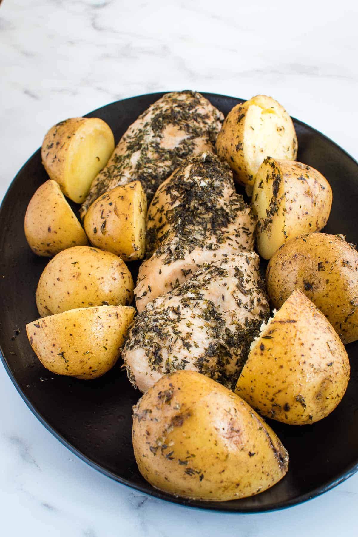 Cooked instant pot chicken and potatoes on a plate.