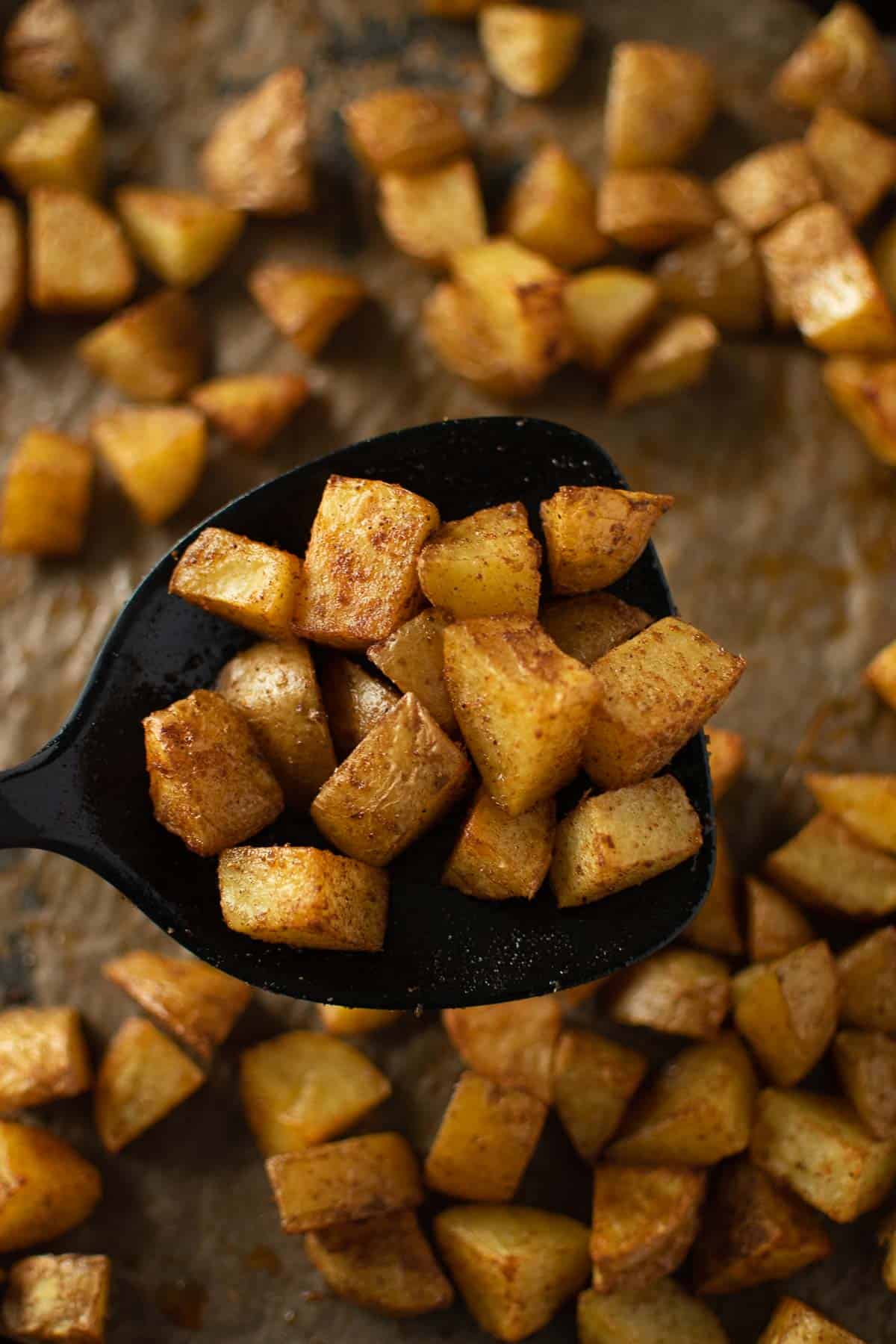 A spatula lifting up a serving of Mexican potatoes.