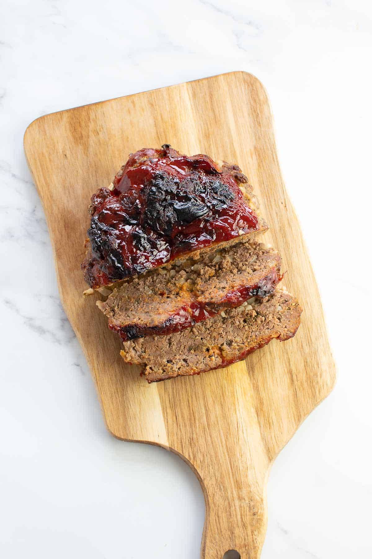 Air fried meatloaf on a chopping board.