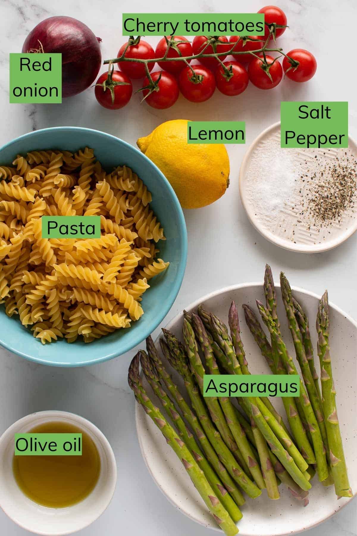 Ingredients required for asparagus pasta salad laid out on a table.