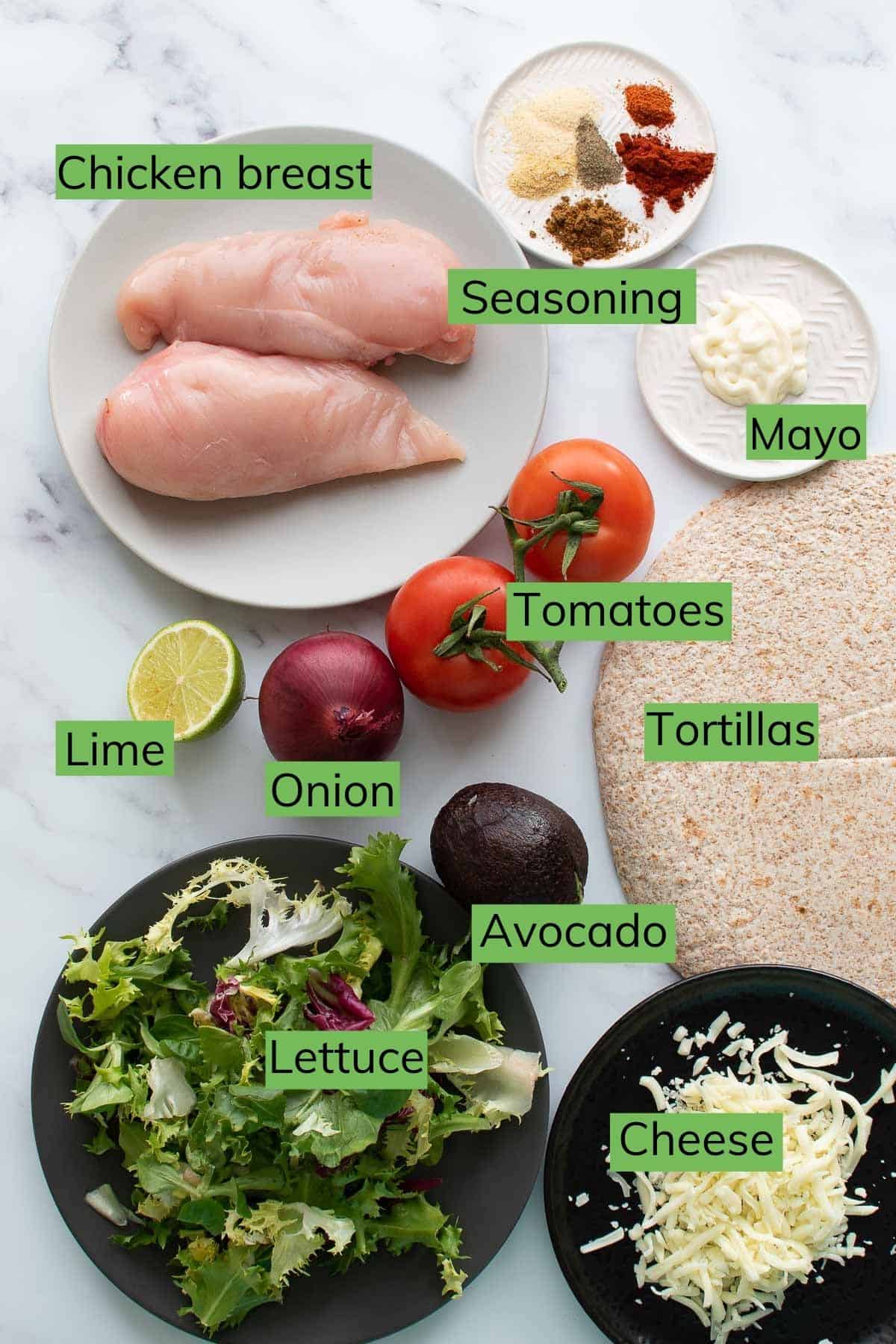 The ingredients required to make avocado chicken wraps laid out on a table.