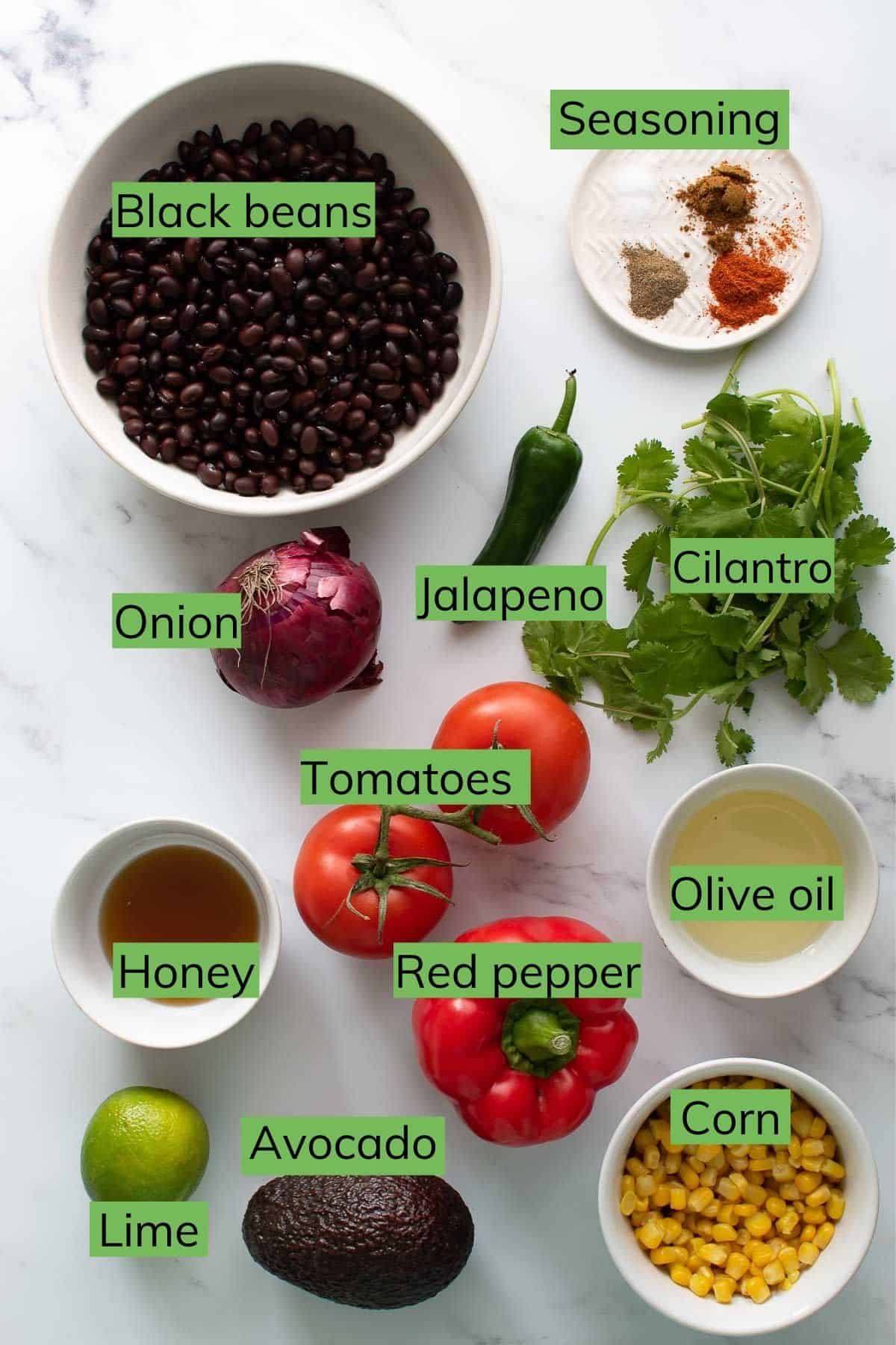 The ingredients required to make black bean corn salad laid out on a table.