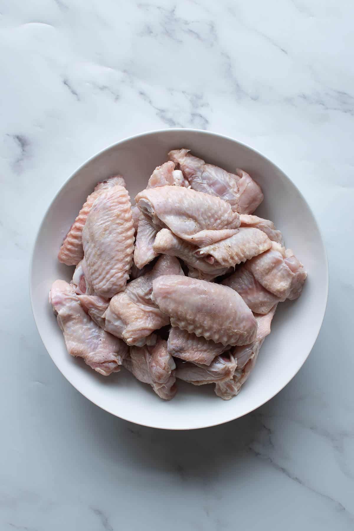 Brined chicken wings in a bowl.