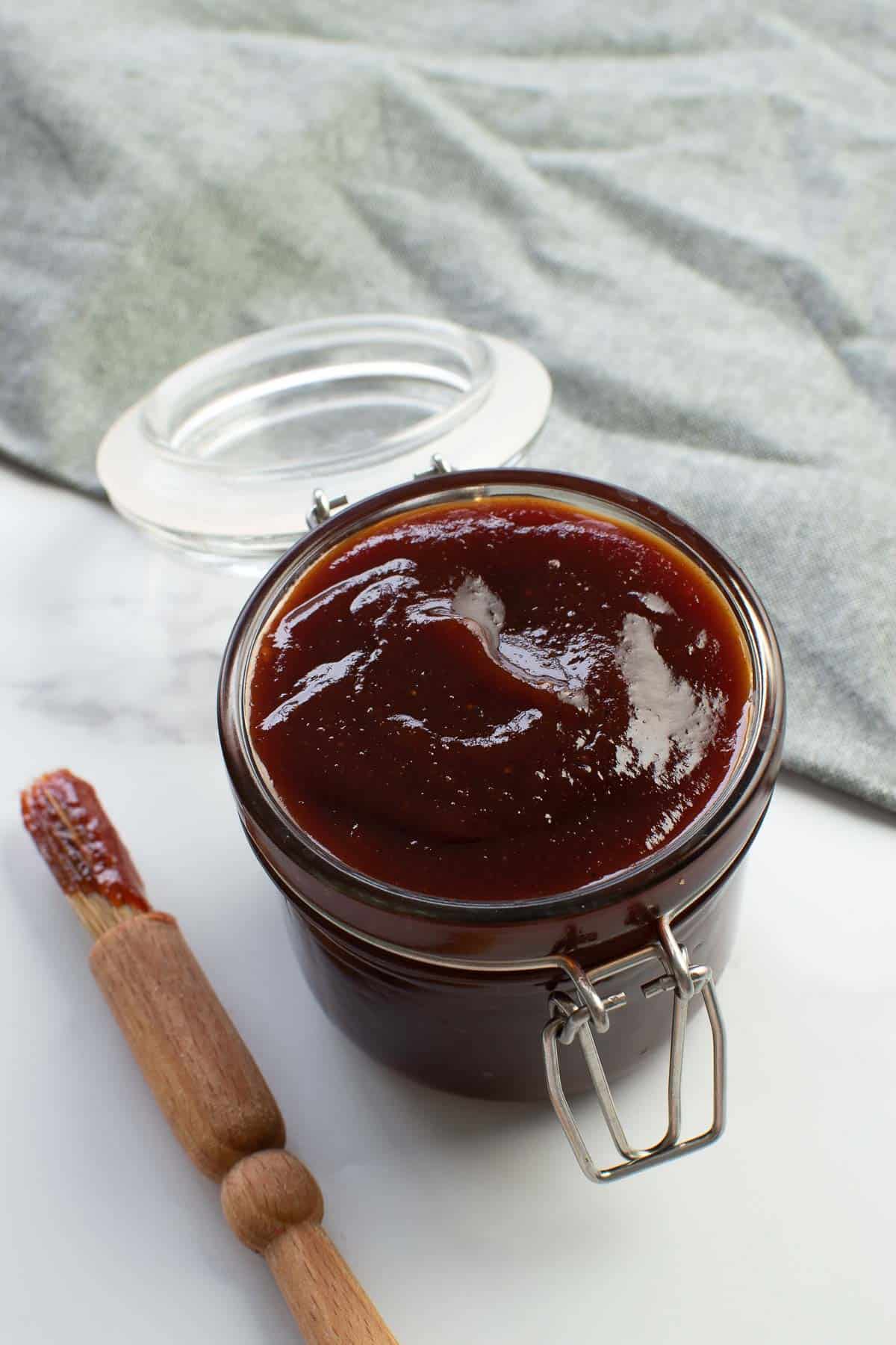 BBQ sauce in a jar with a brush on the side.