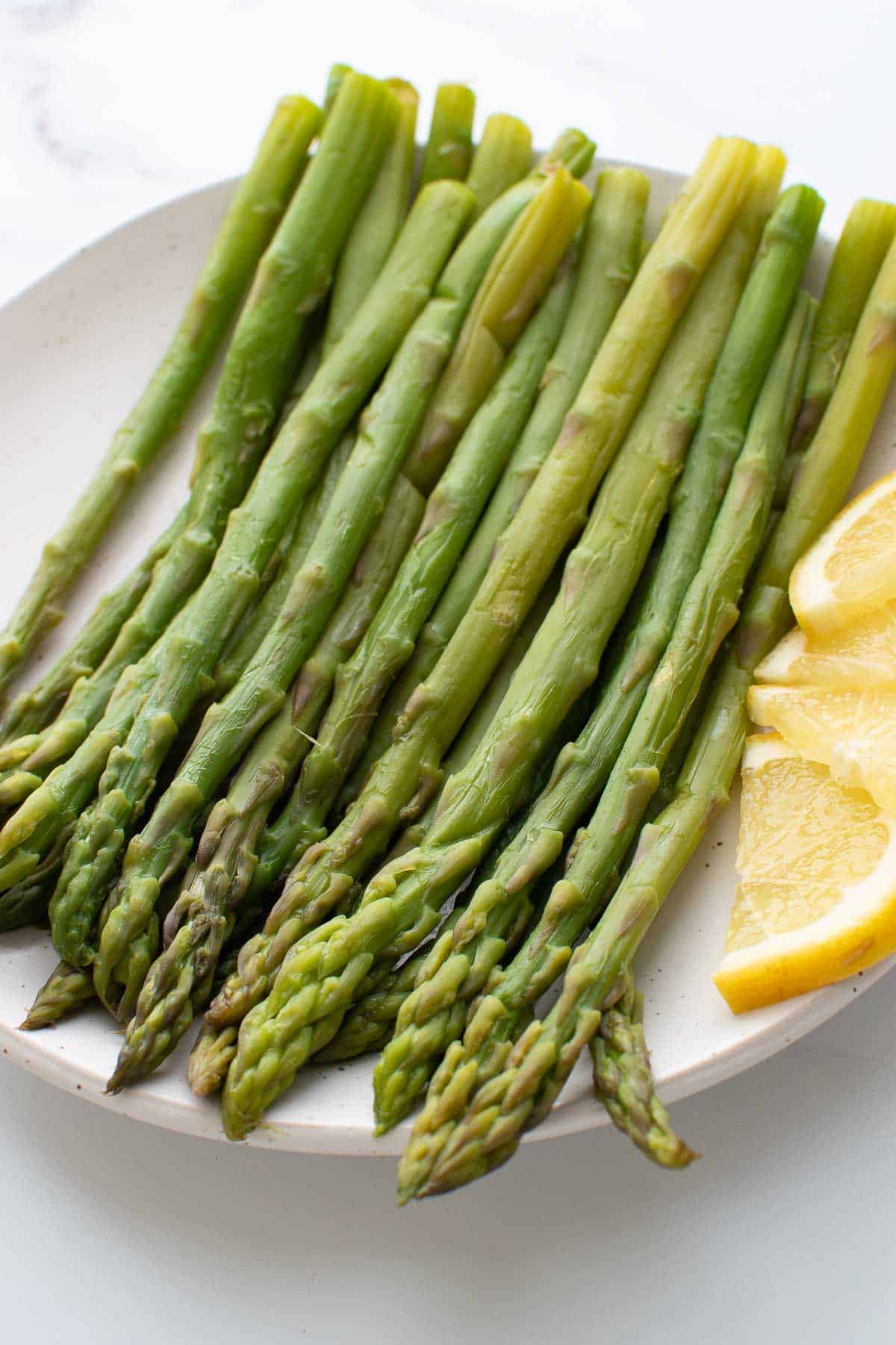 Close up of steamed asparagus with lemon.