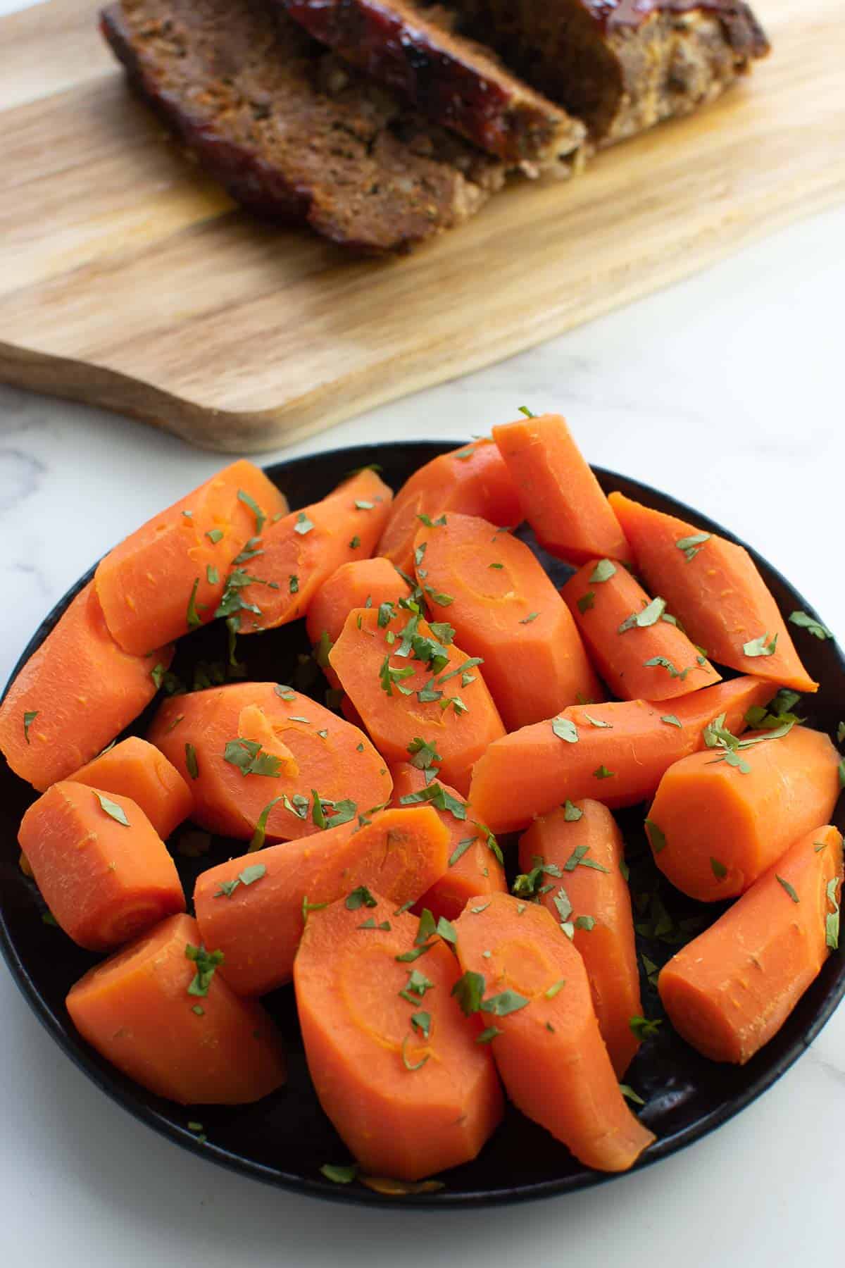 Sliced steamed carrots on a plate.