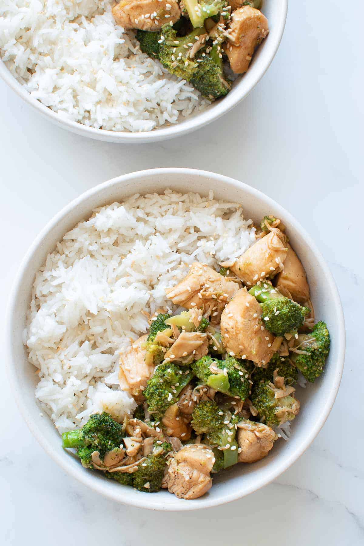 Bowls of chicken and broccoli with rice.