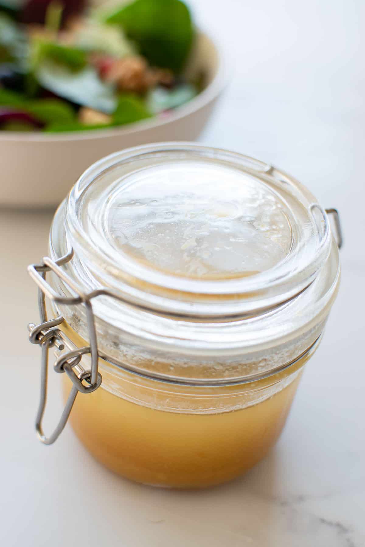A sealed jar with maple syrup vinaigrette on a table.