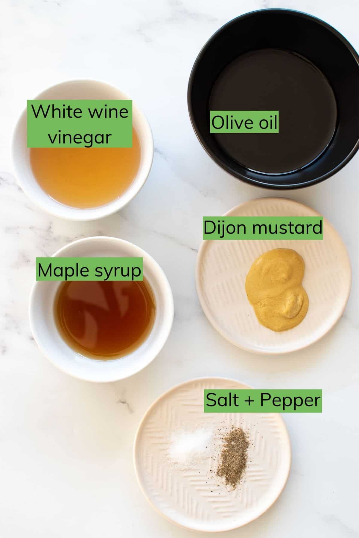 The ingredients required to make maple vinaigrette laid out on a table.
