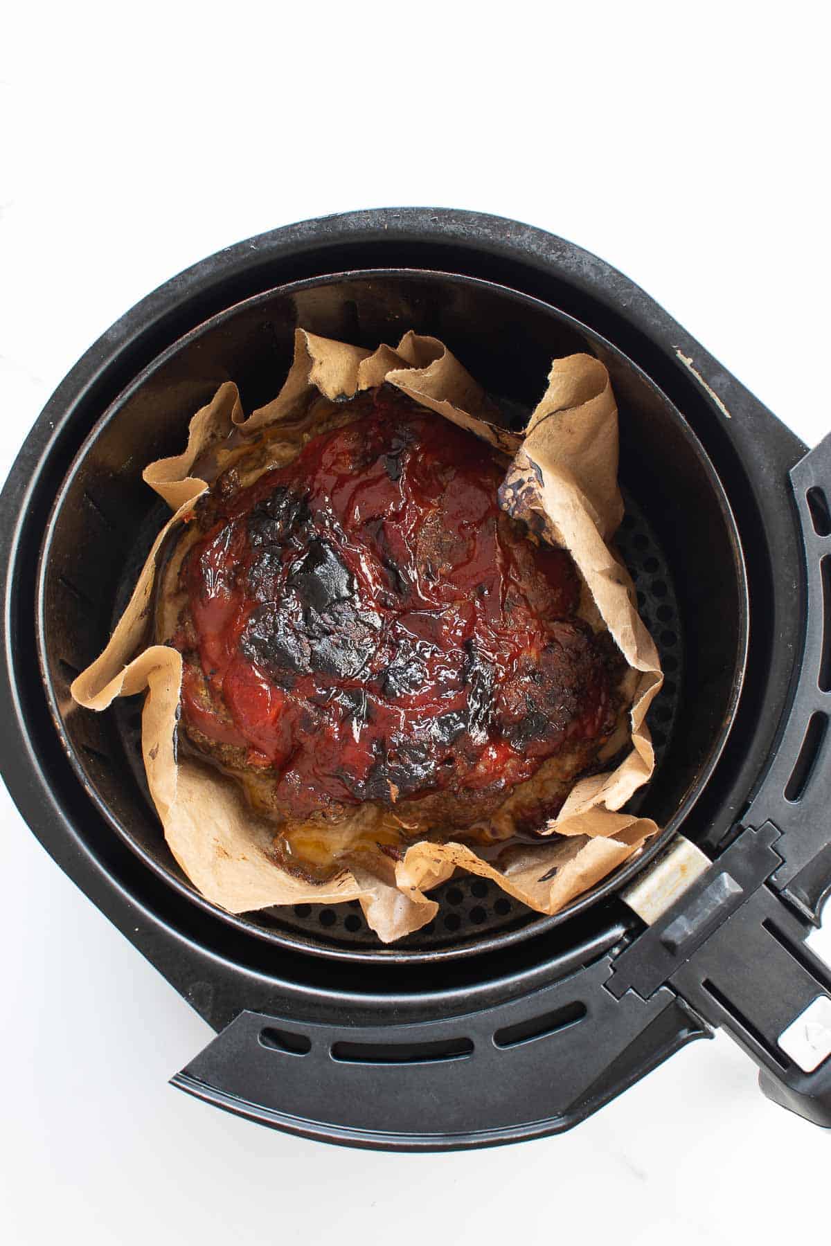 A cooked meatloaf in an air fryer.