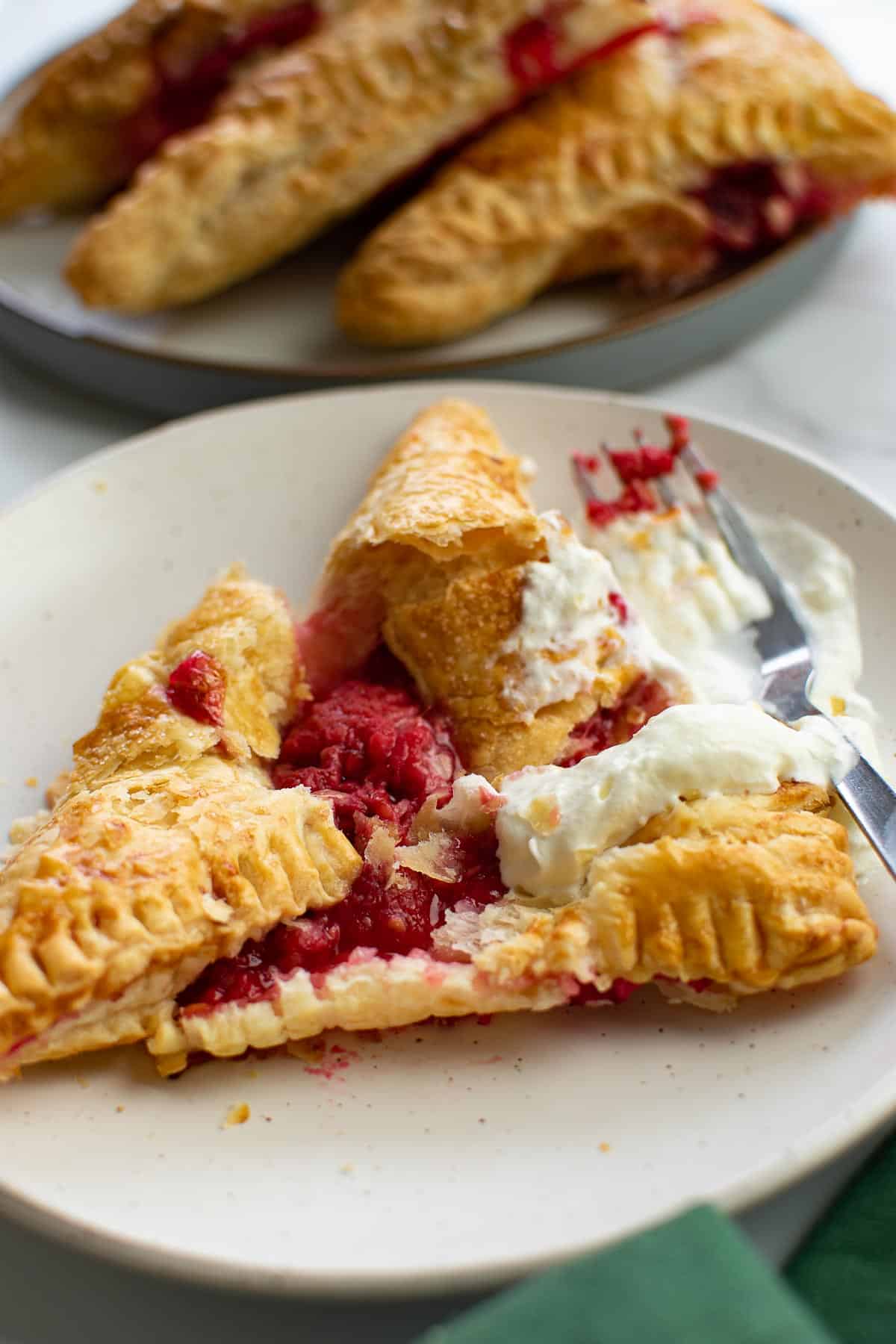 Served raspberry turnovers on plates.