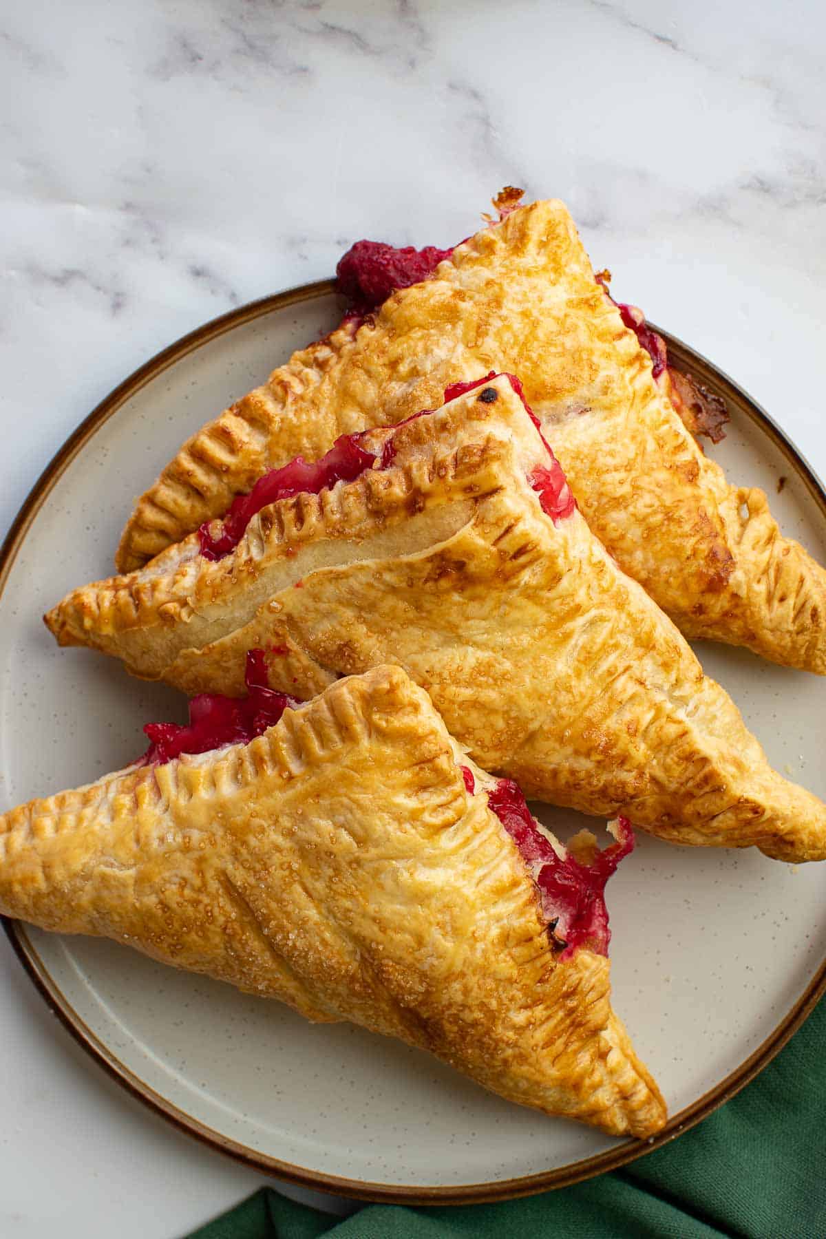 A plate with several raspberry hand pies.