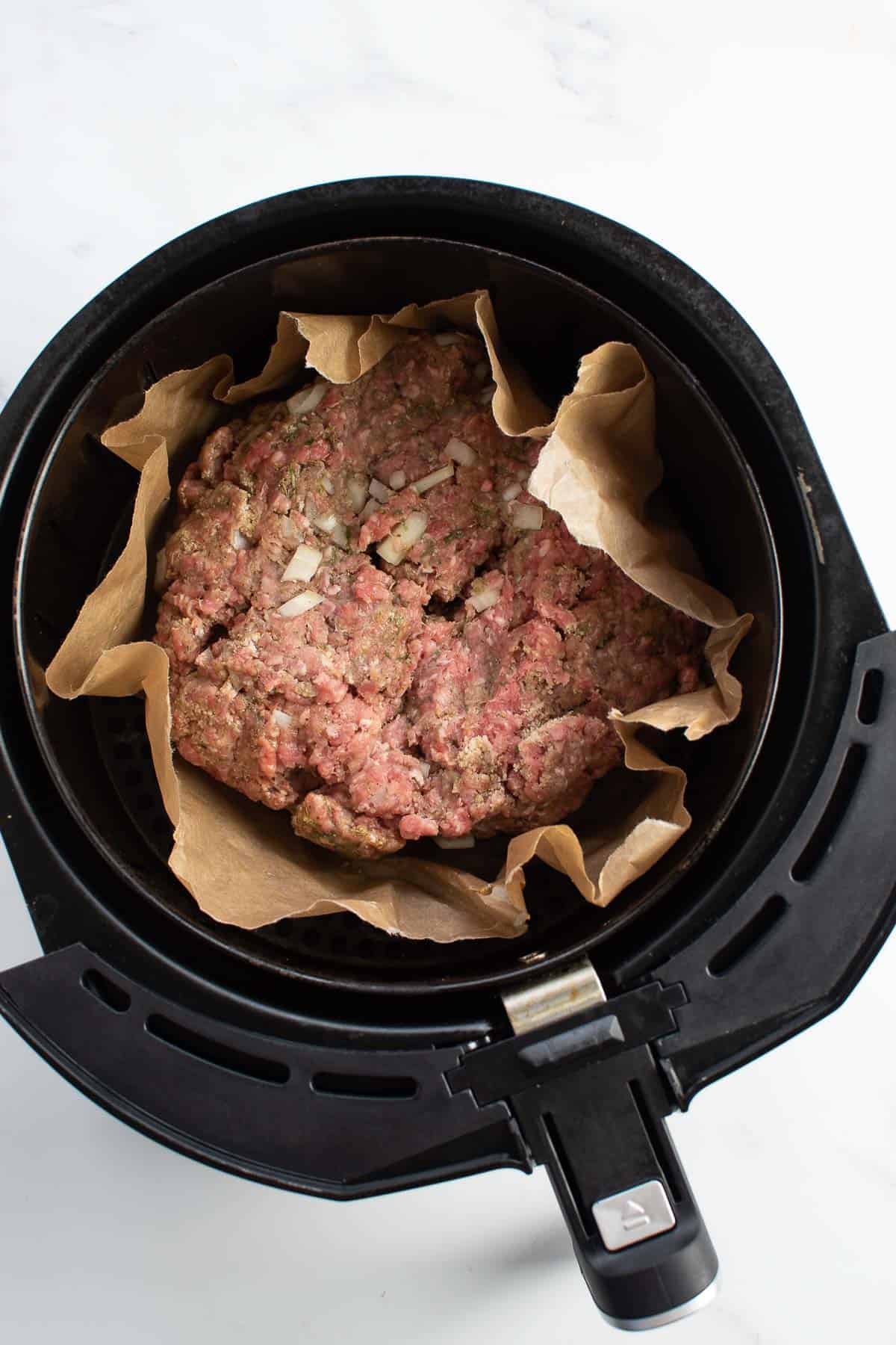 Raw meatloaf in an air fryer.