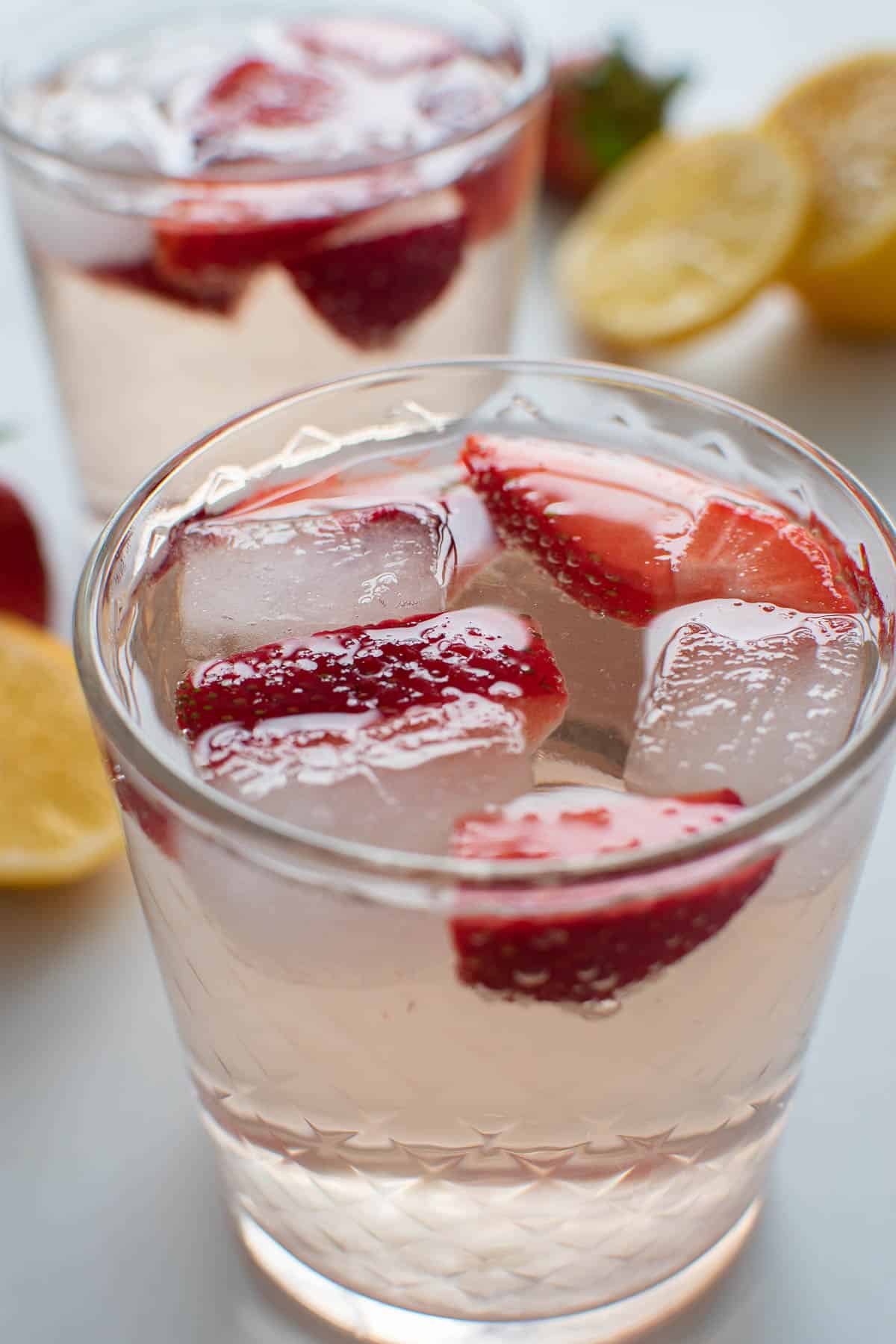 Rose spritzer with strawberries and ice cubes.