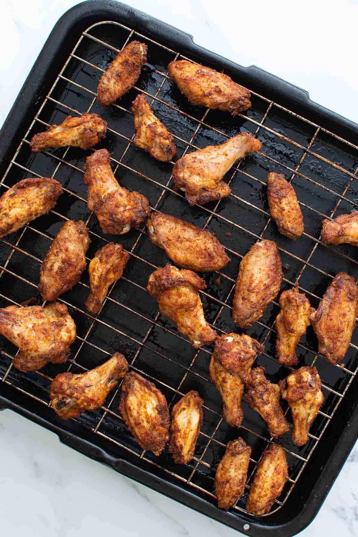 Chicken wings on a wire rack.