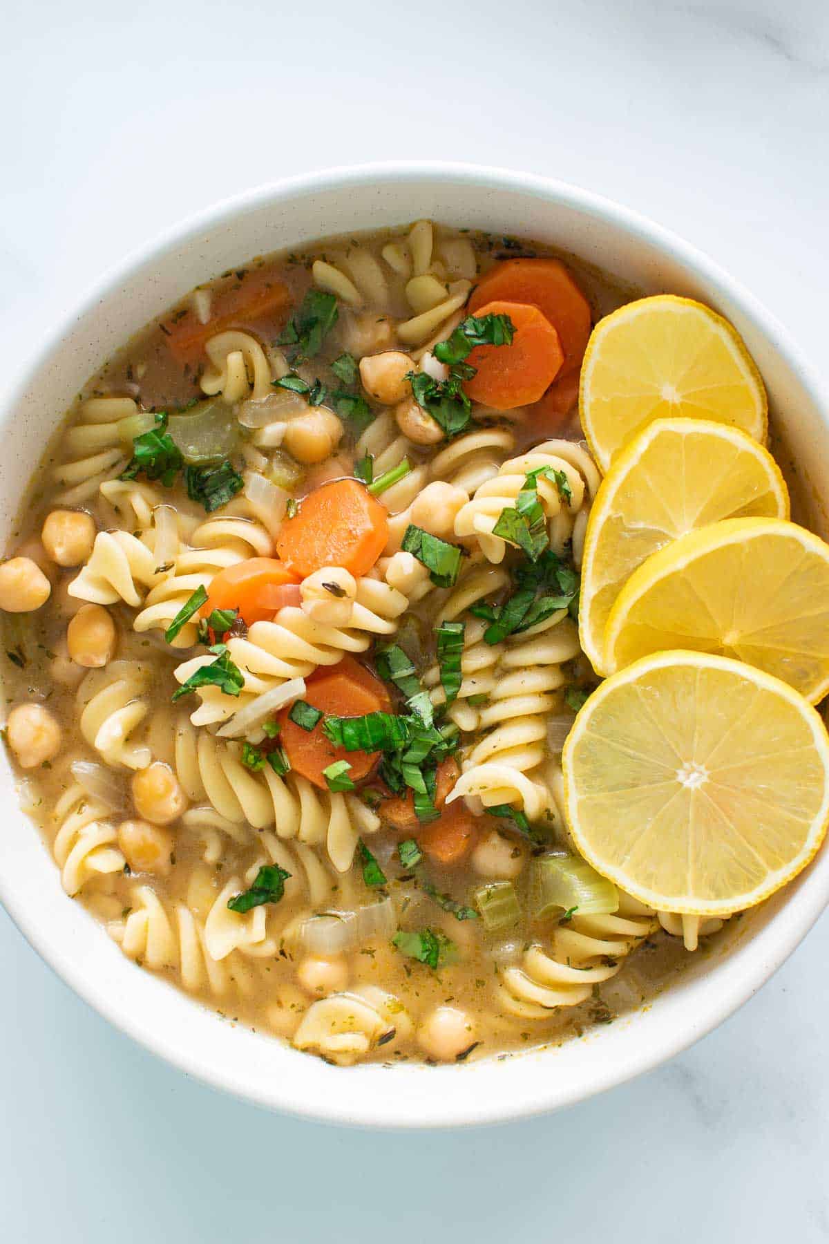 Close up of a bowl of chickpea noodle soup.