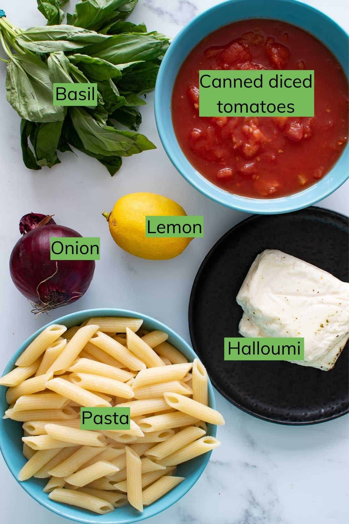 Ingredients for halloumi pasta laid out on a table.