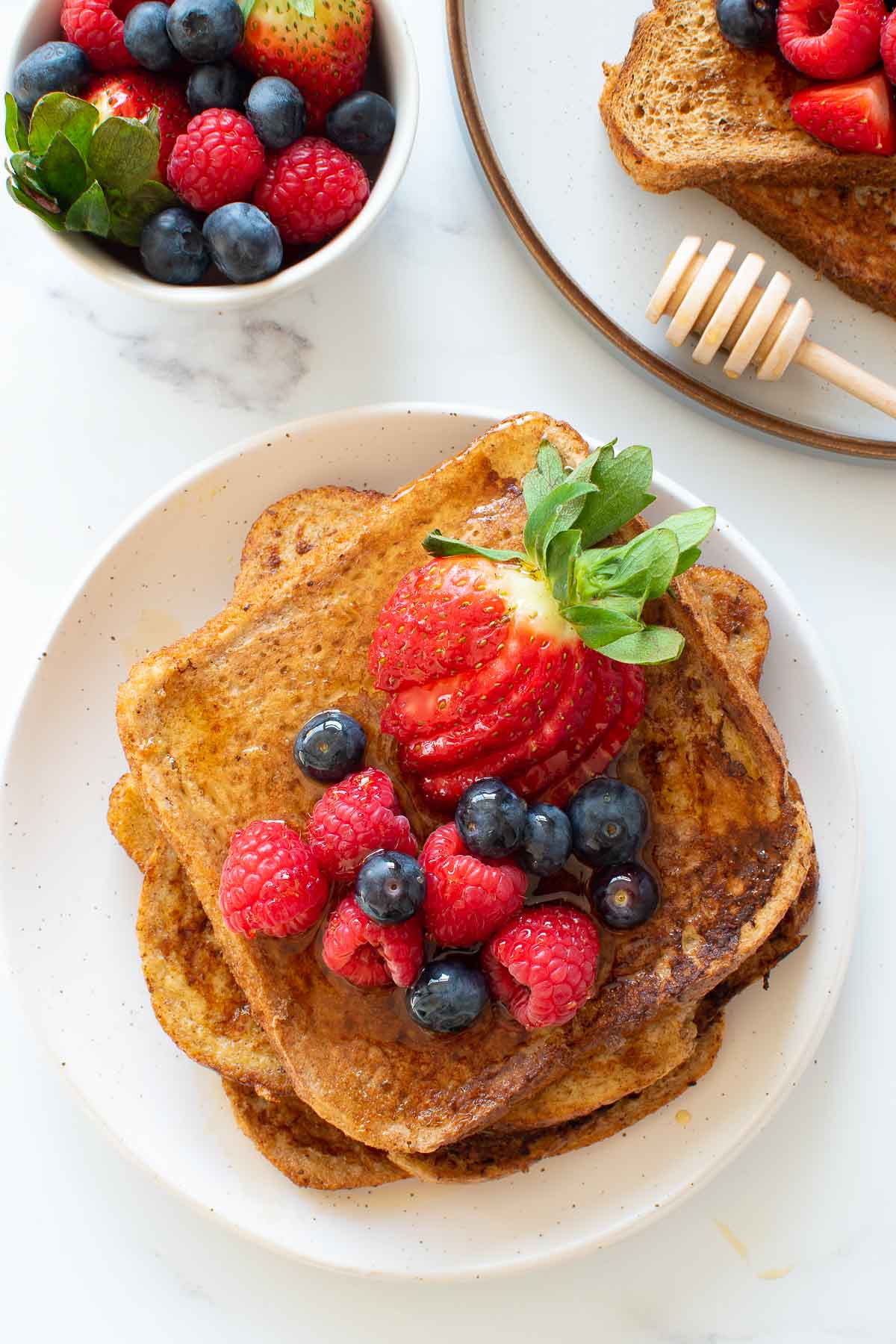 A stack of wholemeal French toast with strawberries.