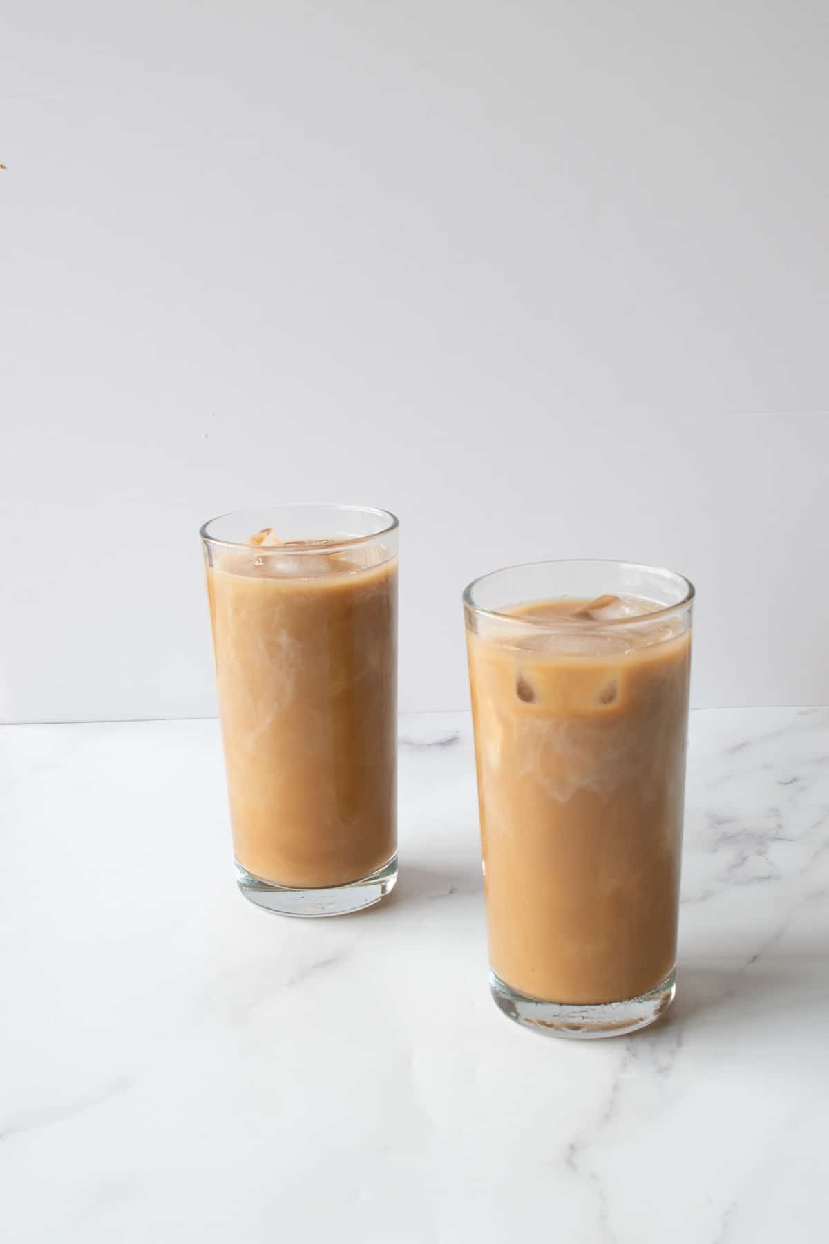 Tall glasses of copycat starbucks iced caramel latte.