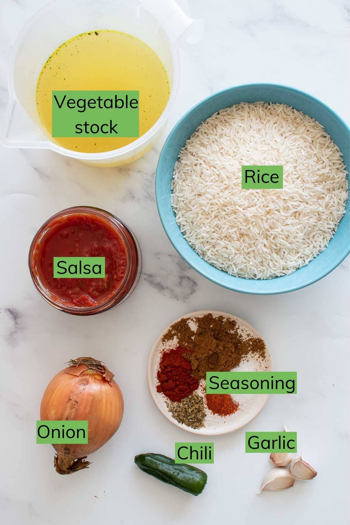 The ingredients needed to make Spanish rice laid out on a table.