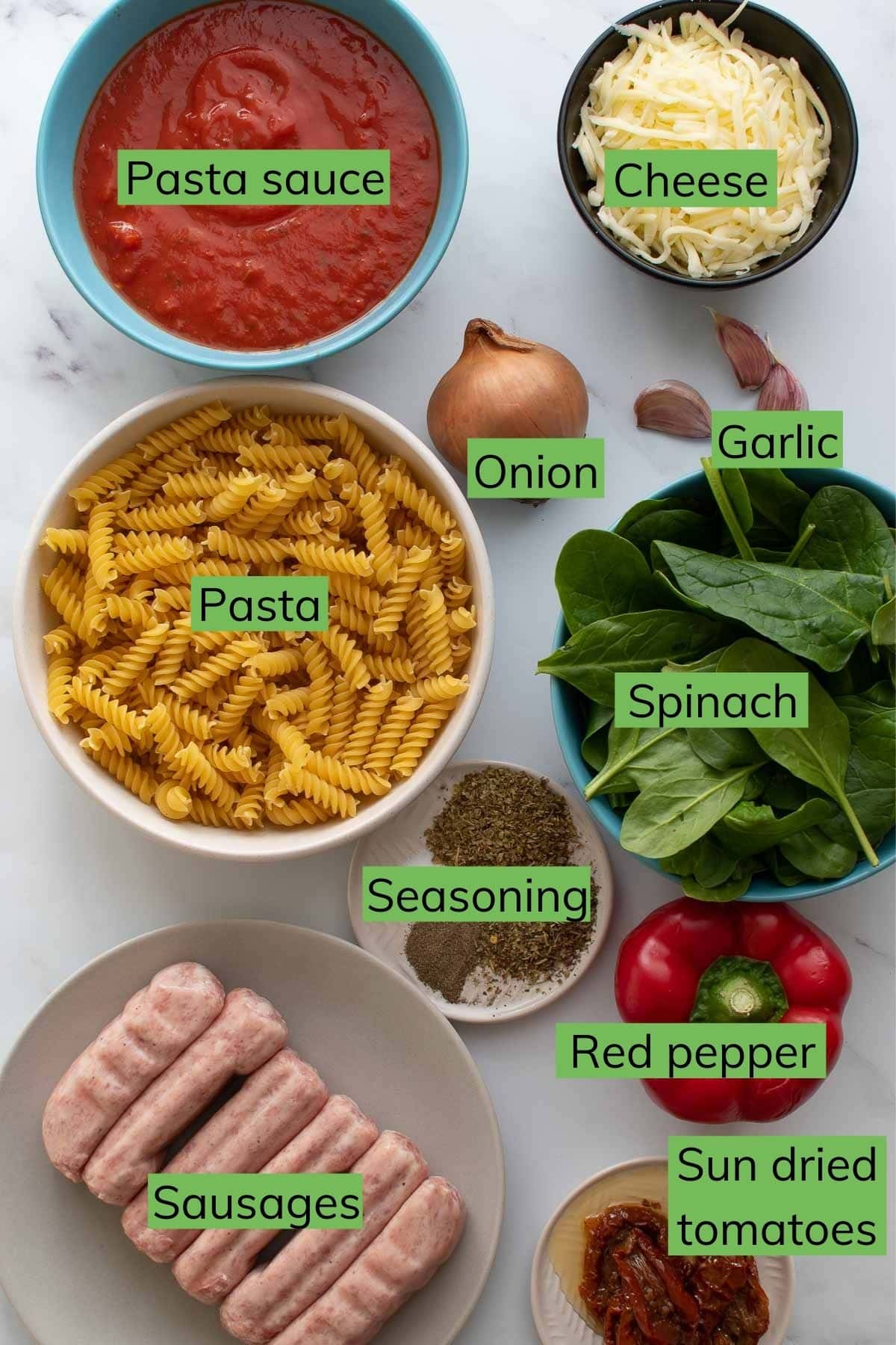 Ingredients needed to make Sausage Pasta Bake laid out on a table.