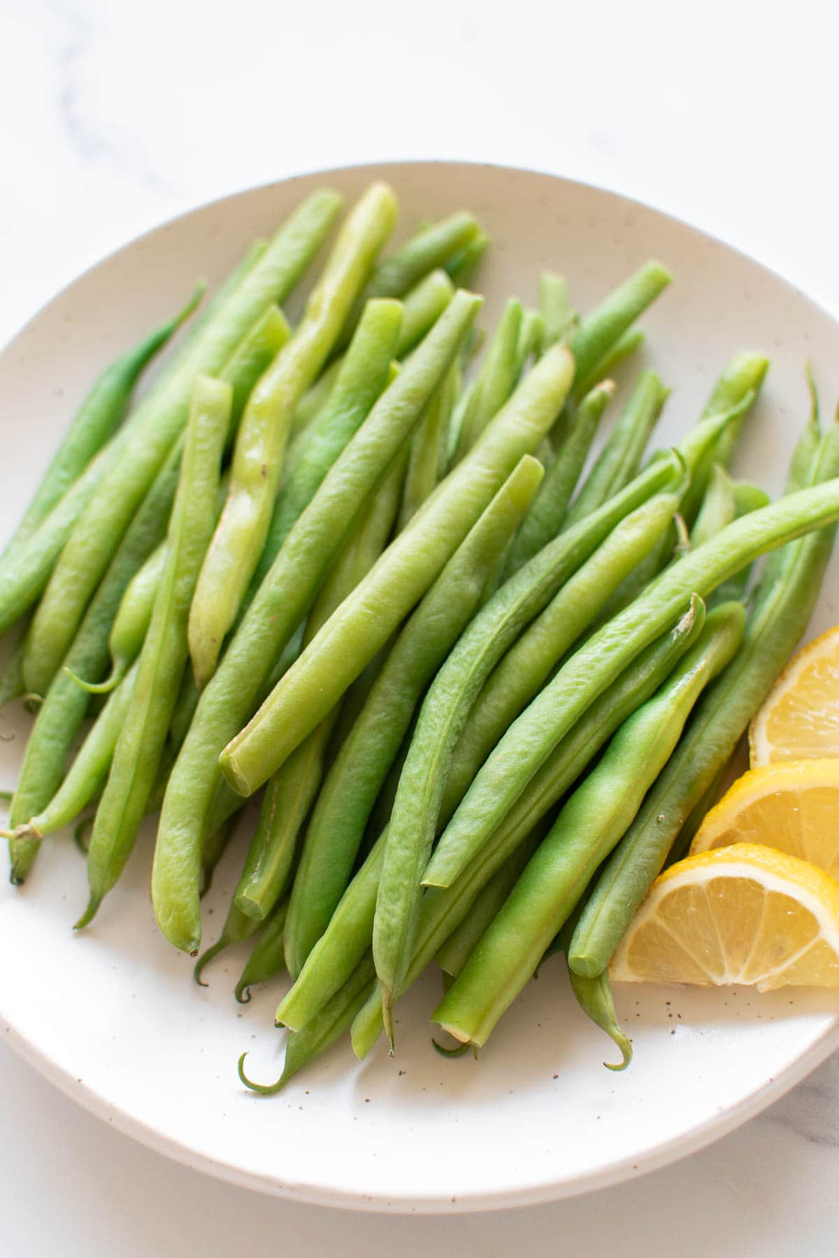 Close up of a plate of steamed green beans.