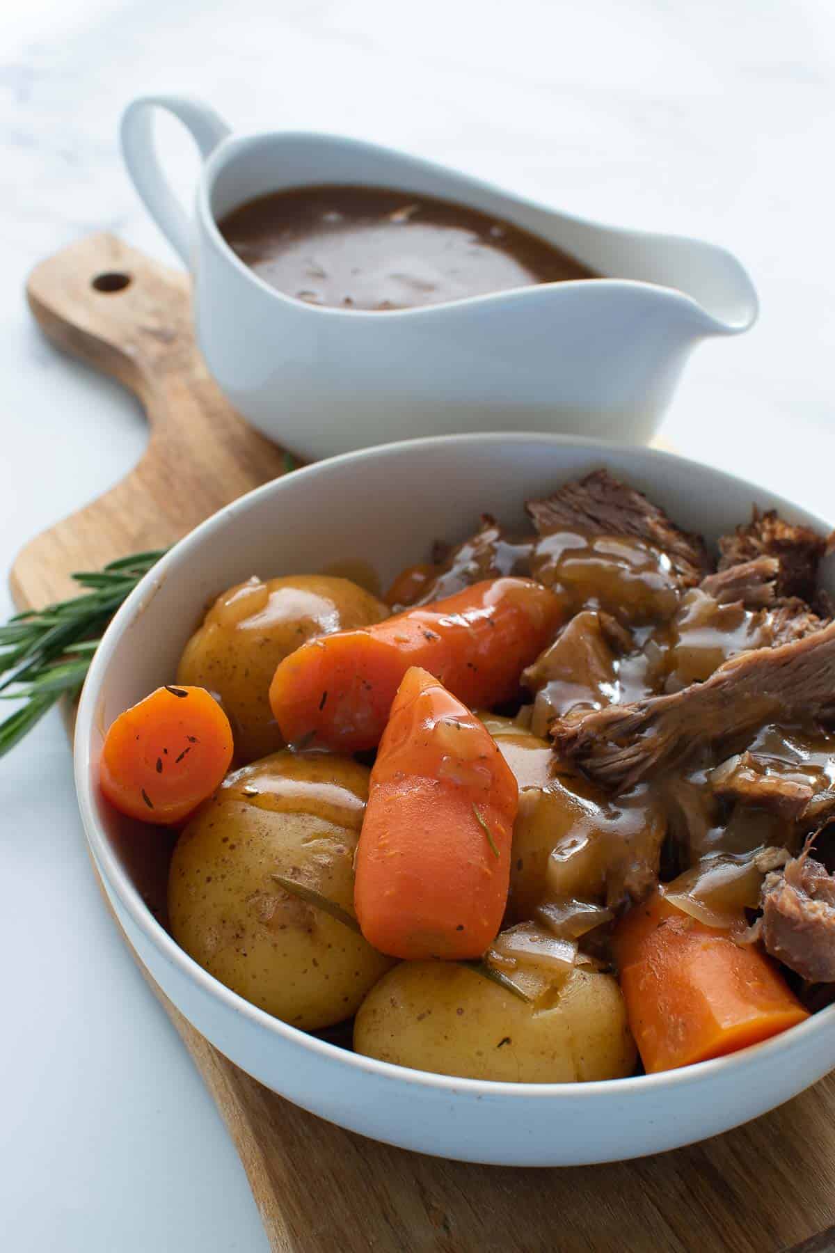 Beef, potatoes and carrots with gravy in a bowl.