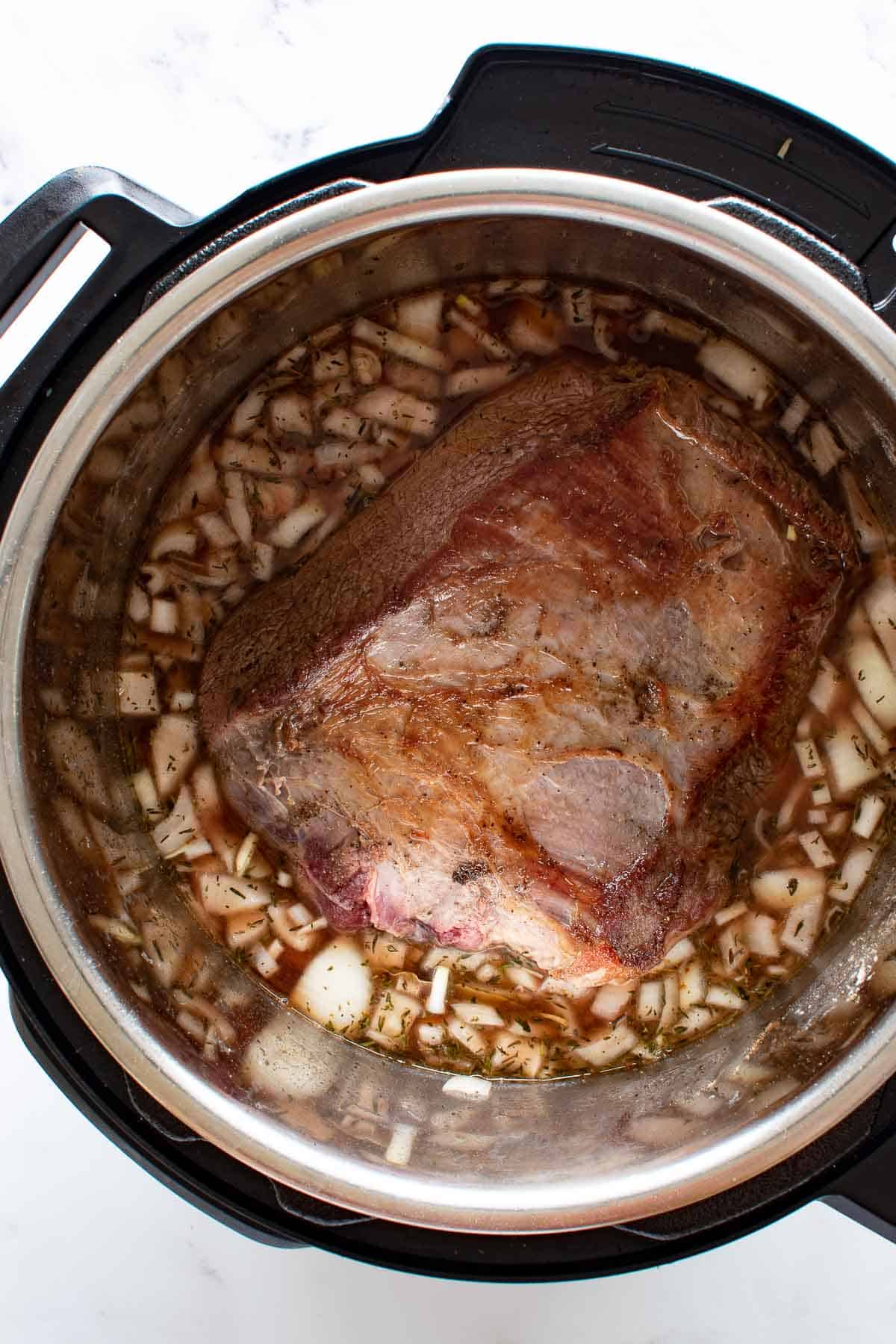 A roast cooking in an instant pot.