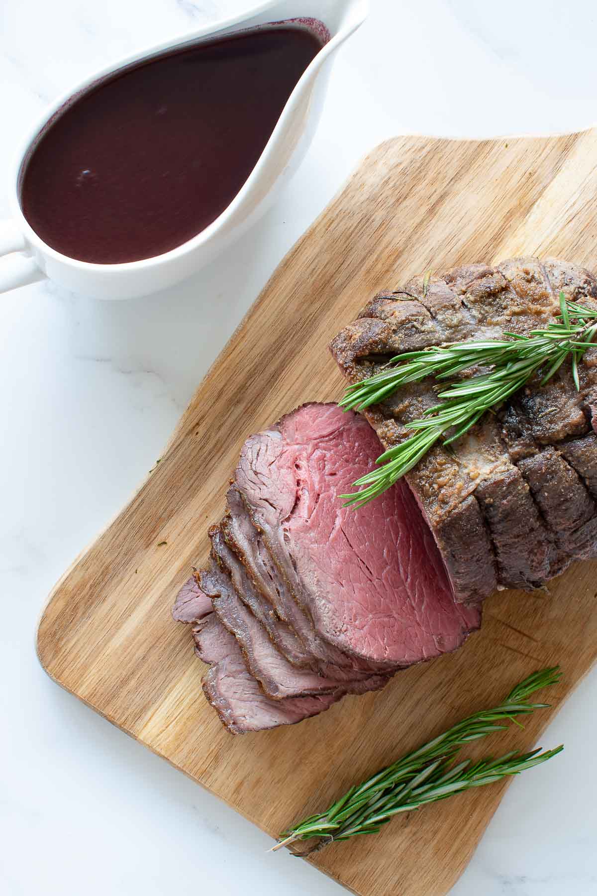 Sliced roast beef with gravy on the side.