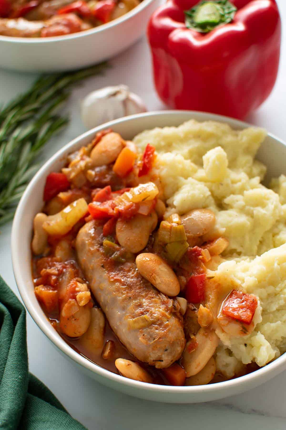 A bowl of sausage casserole and mashed potatoes.