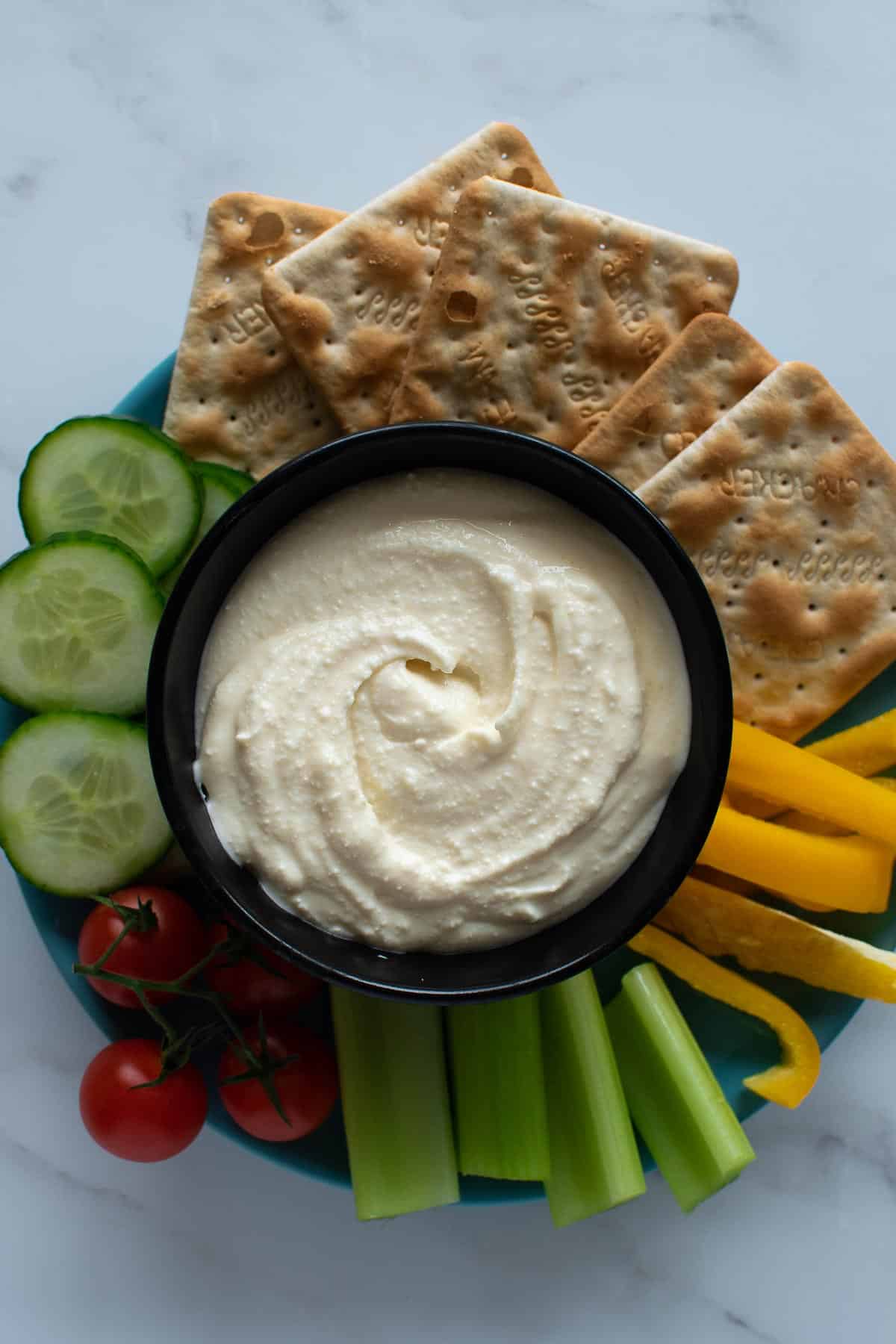 A plate with sweet whipped feta dip and vegetables.