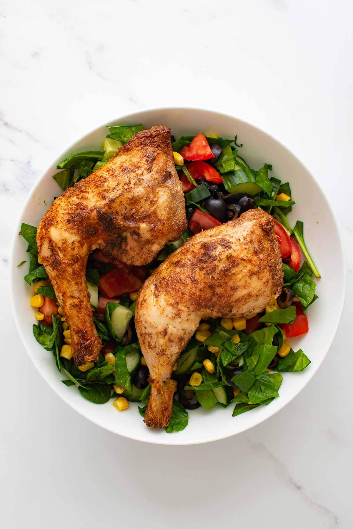 Crispy chicken leg quarters with salad.