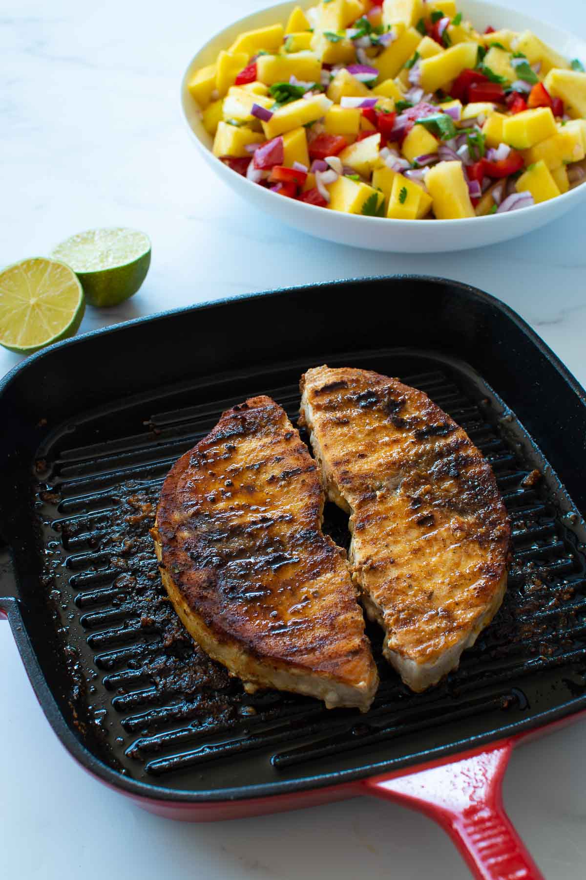 Seared swordfish with salsa in the background.