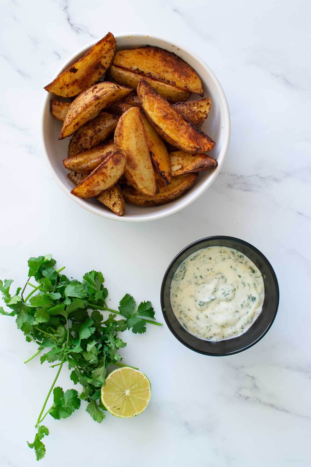 Cilantro lime mayonnaise dip with potato wedges.