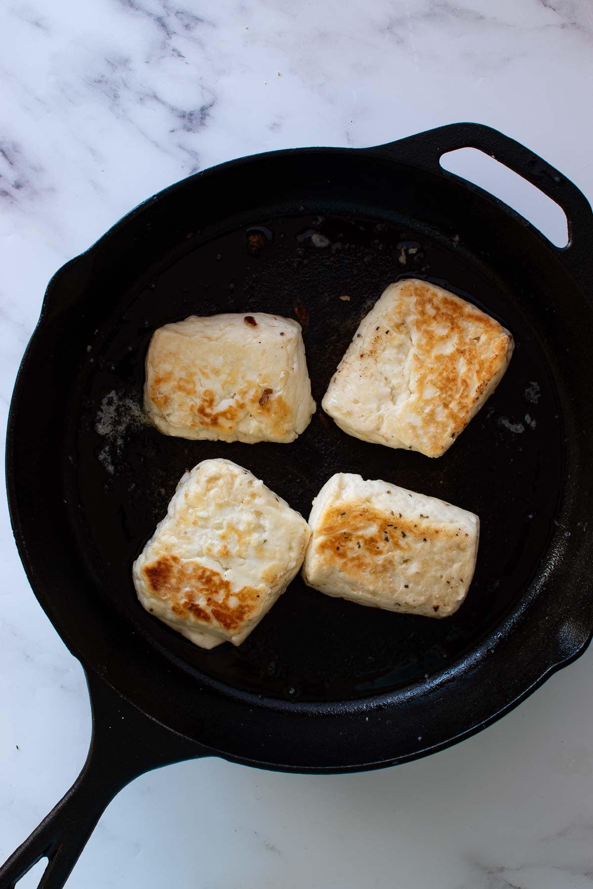 Cooked halloumi in a pan.